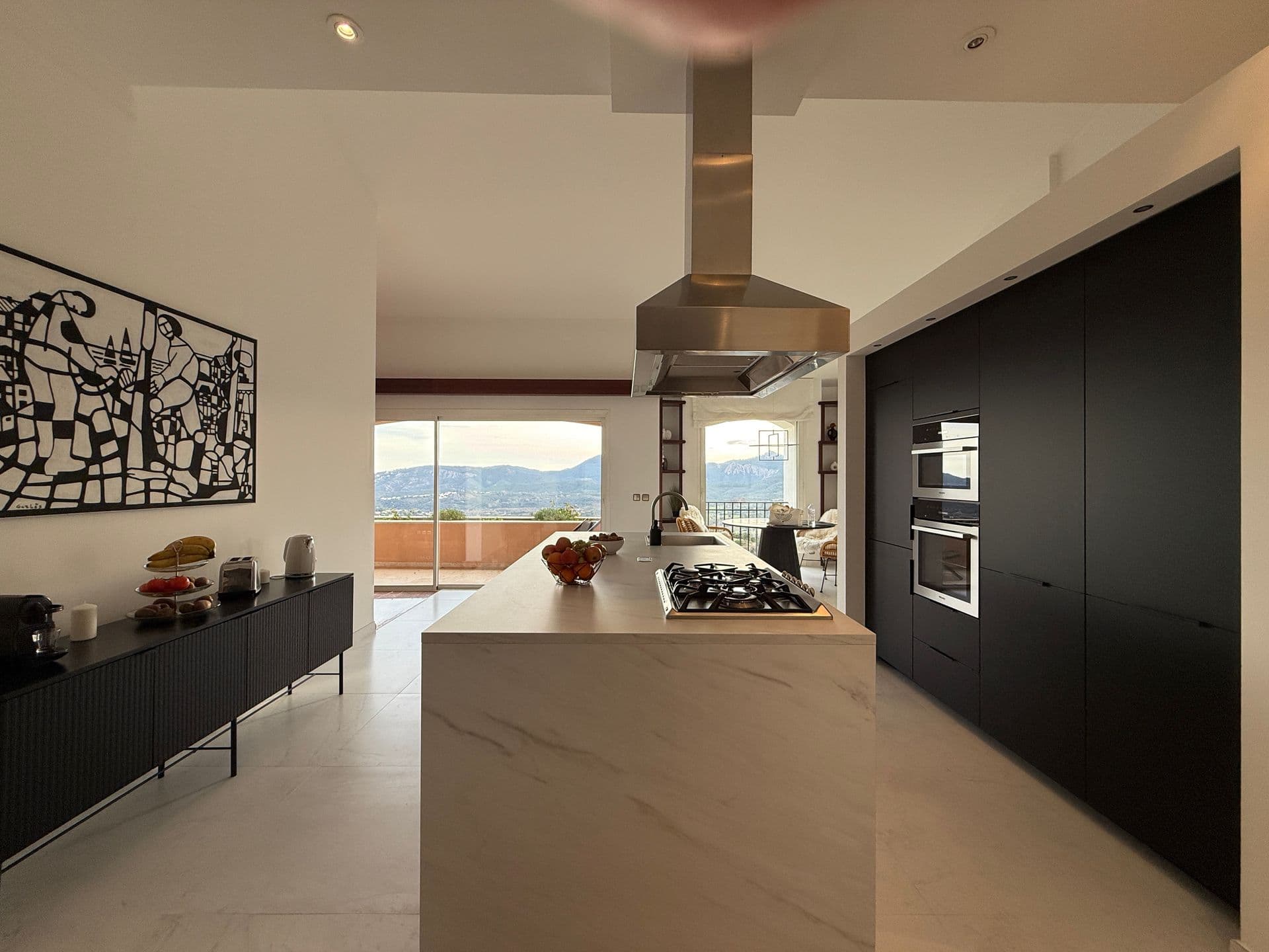 Dark modern kitchen with central island and integrated appliances at Golden Escape