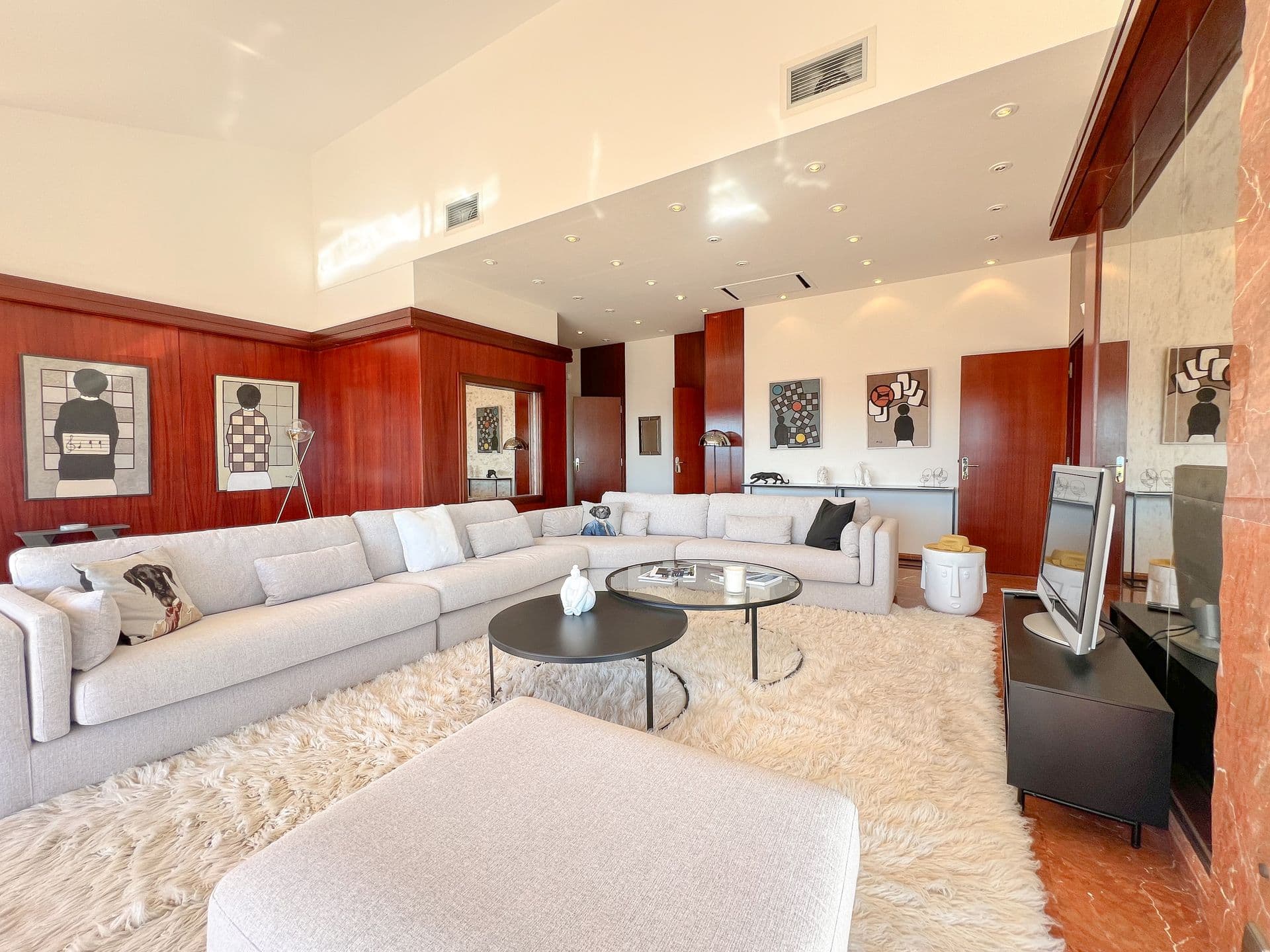 Open-plan living room with white sofas and shaggy rug at Golden Escape