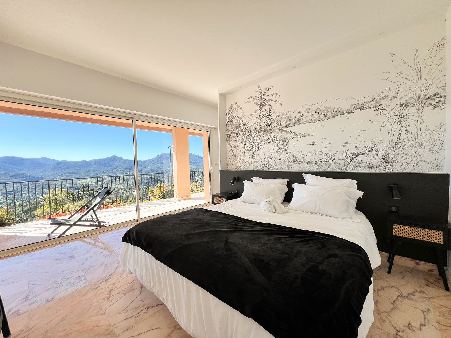 Bedroom with black upholstered headboard and sea-view terrace access at Golden Escape