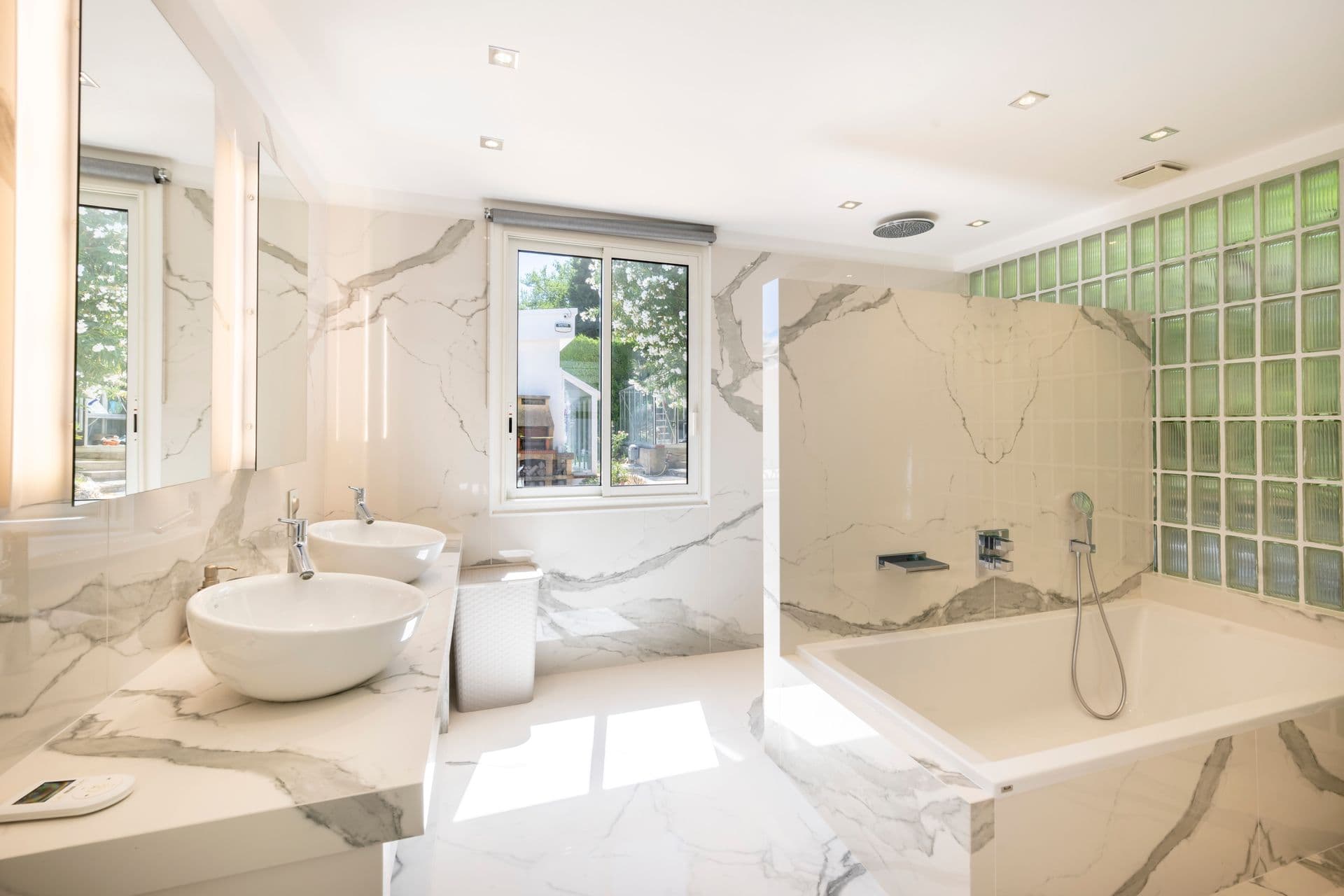 Marble bathroom with bathtub at Olive and Sea