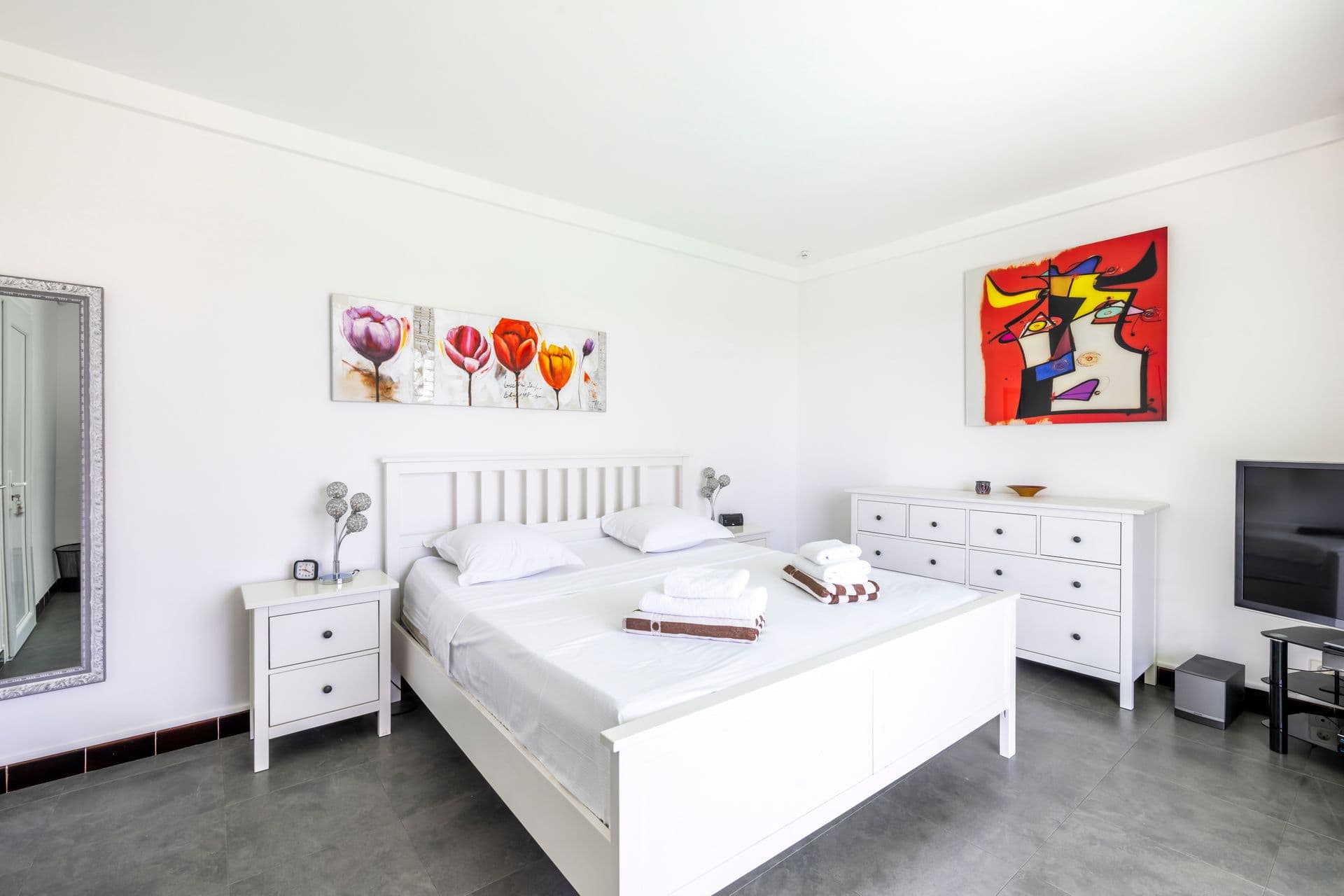 Bedroom with white bed linen and artwork at Olive and Sea