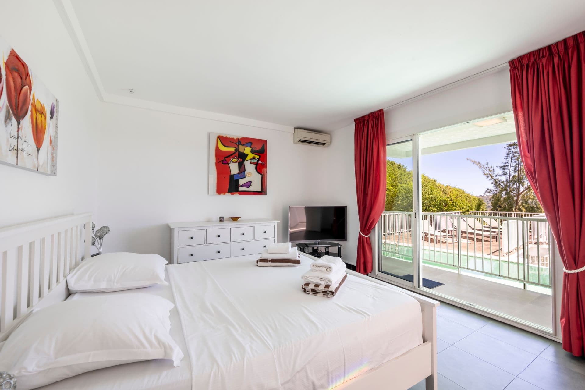 Twin bedroom with red curtains and terrace access at Olive and Sea