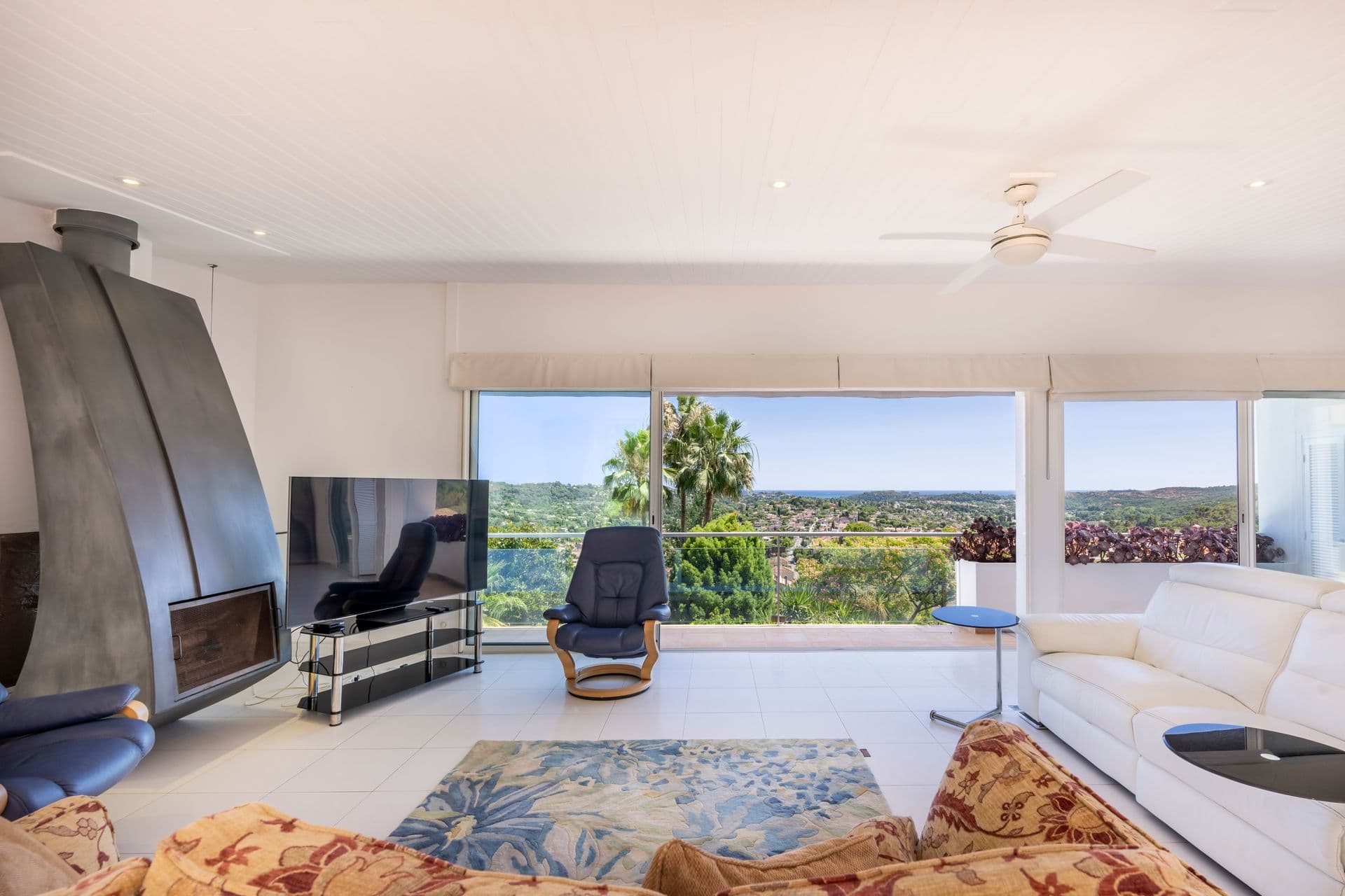 Living room with fireplace and panoramic countryside view at Olive and Sea