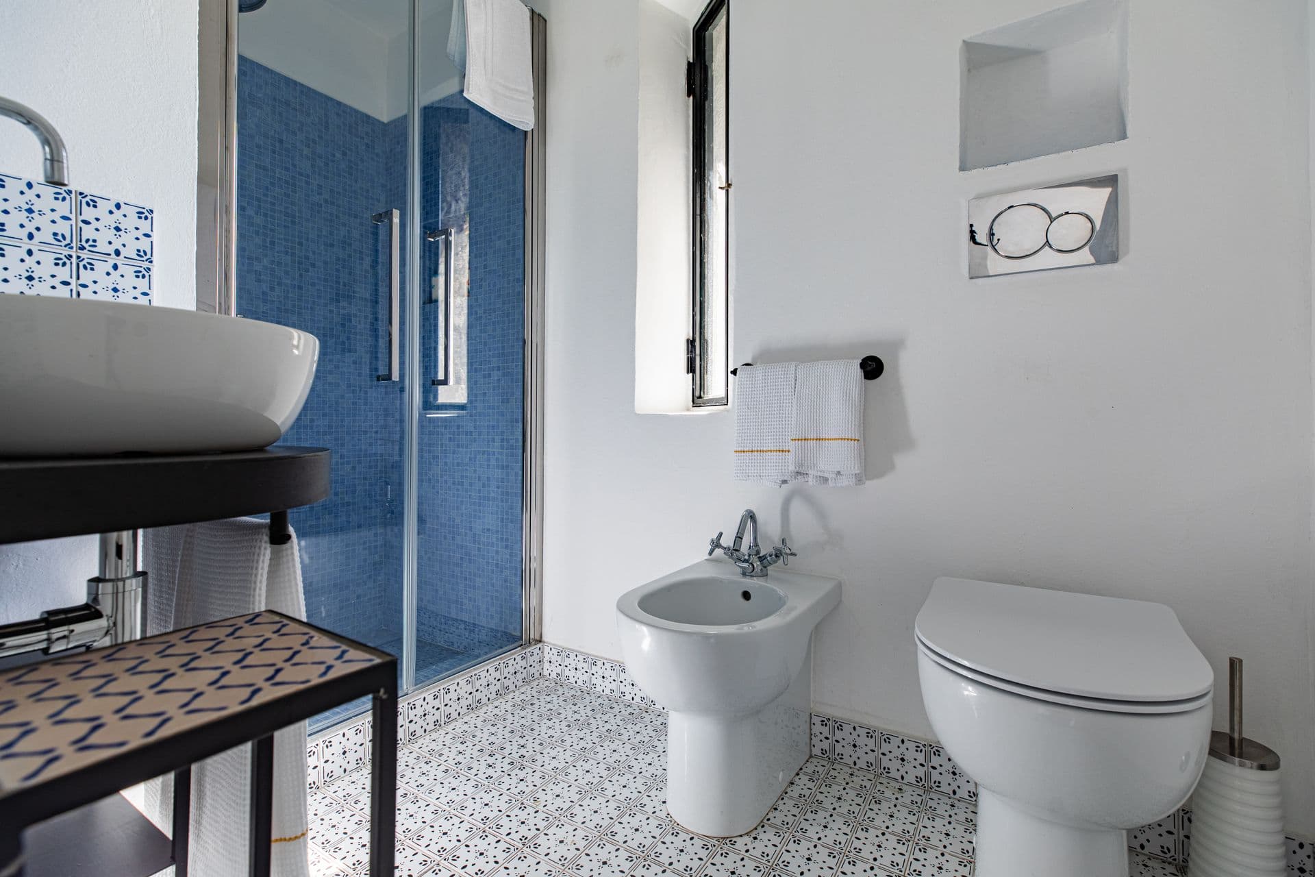 Bathroom with blue patterned floor tiles, sink and bidet