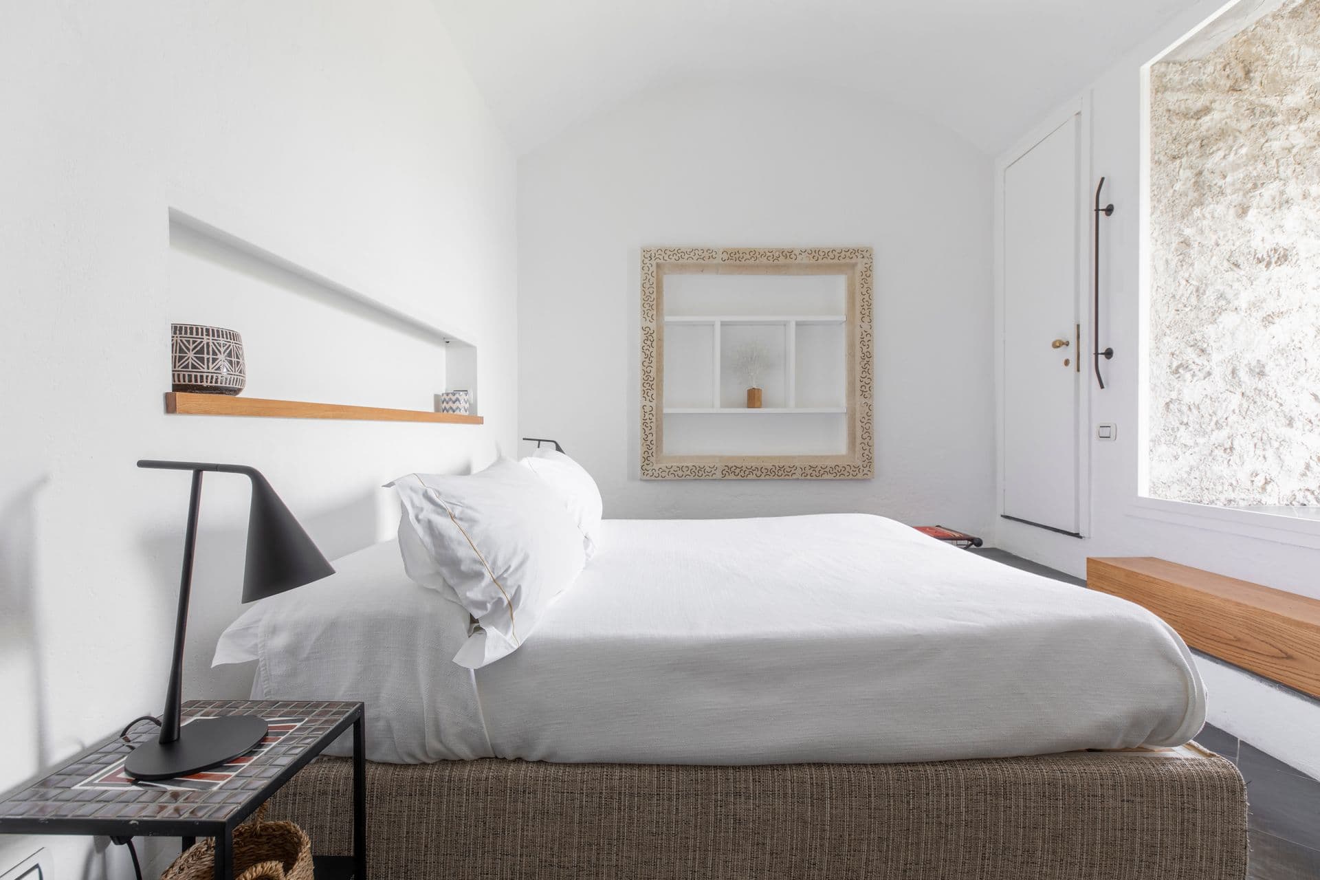 Neutral-toned bedroom with white bed and framed artwork