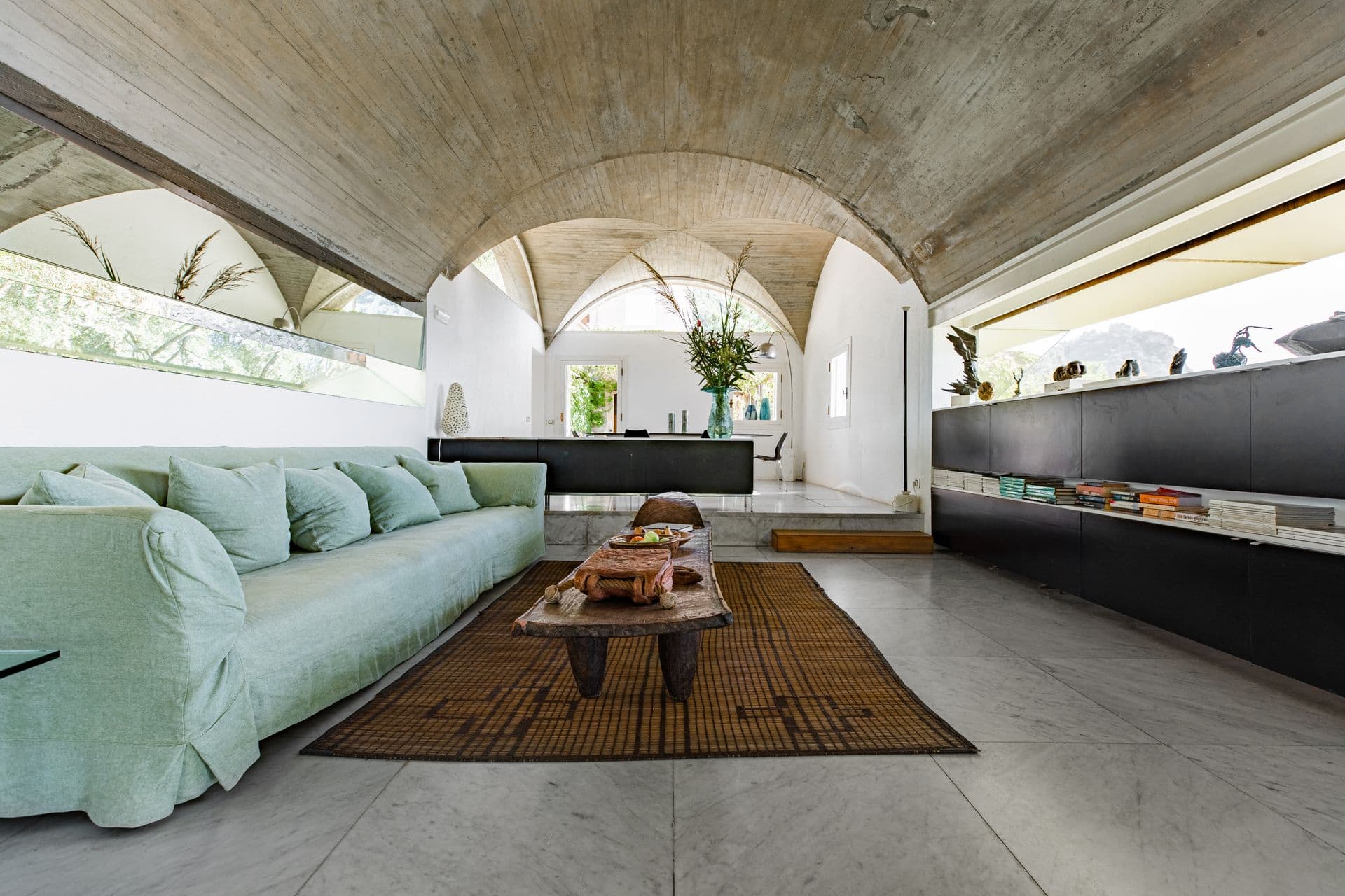 Vaulted living room with pale sofa, low table and sea-facing windows