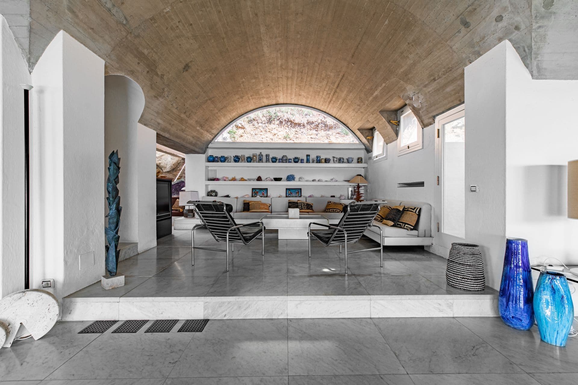 Living space beneath a vaulted archway with sculptural furniture