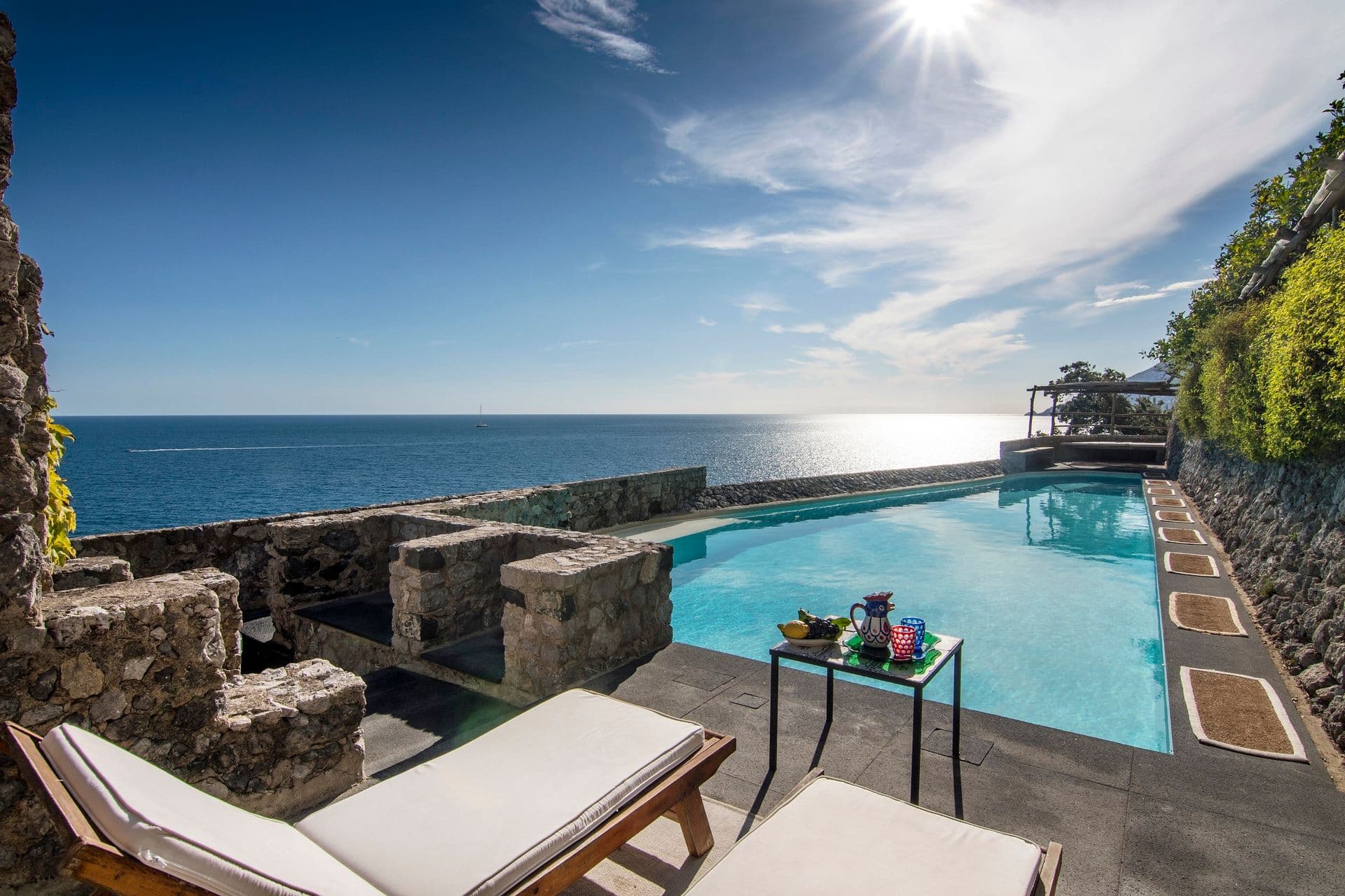 Infinity-edge pool cut into the cliffside with panoramic sea views