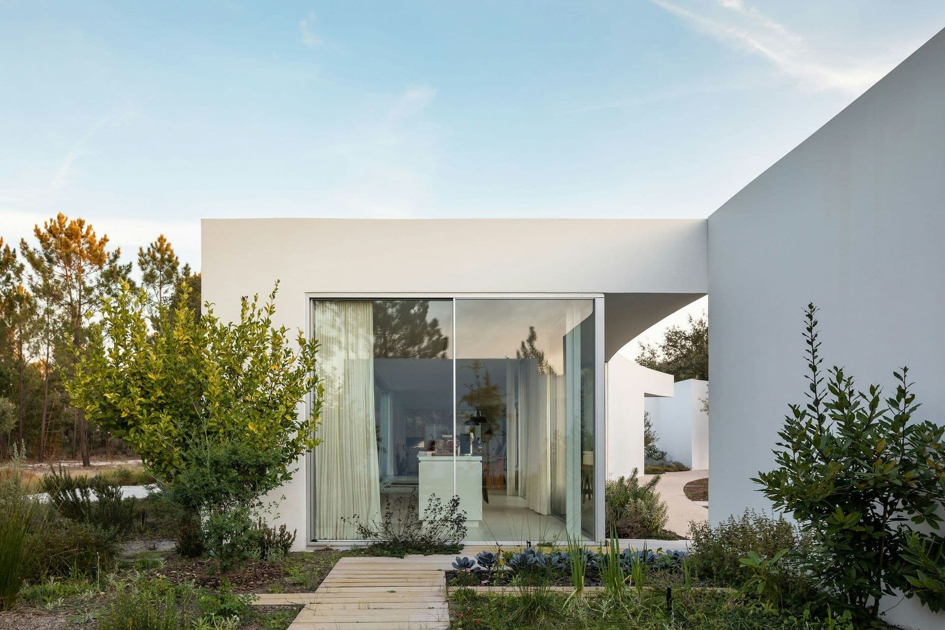 White modernist facade with sculptural curved wall at The Spirit of Joy, Comporta