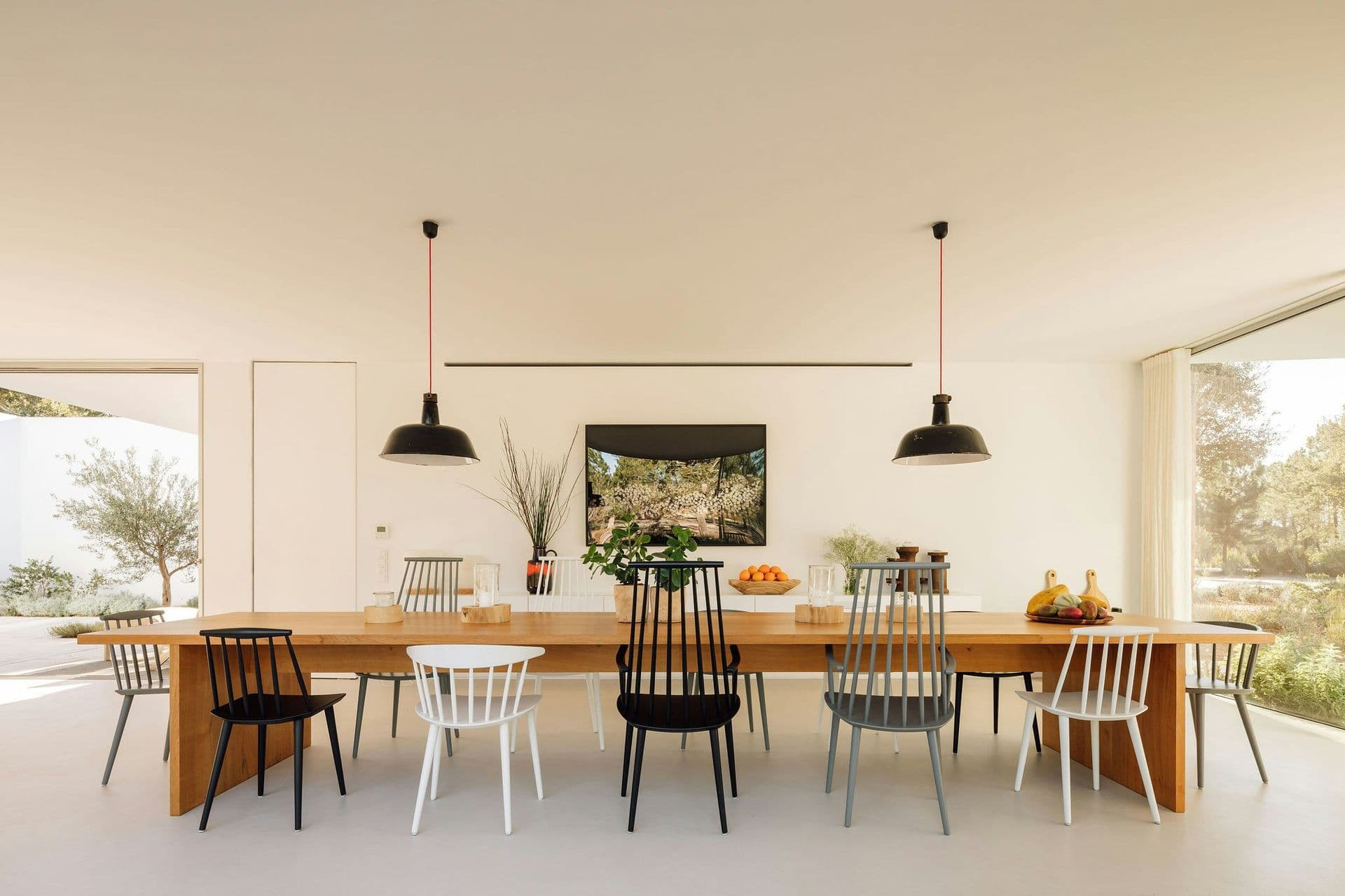 Long timber dining table with pendant lights at The Spirit of Joy, Comporta