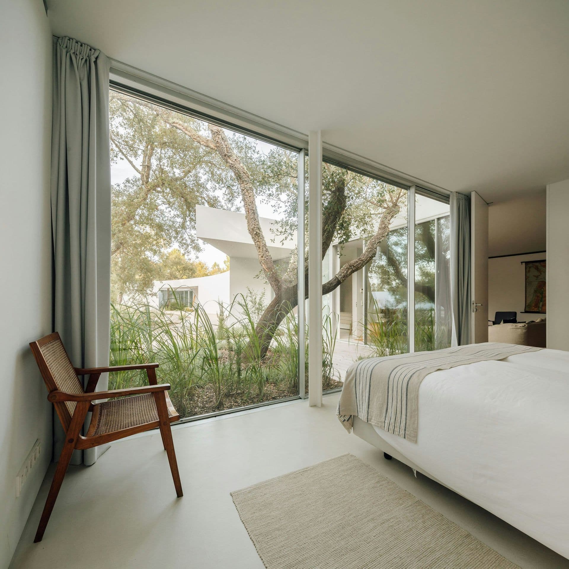 Bright bedroom with a reading chair and garden view at The Spirit of Joy, Comporta