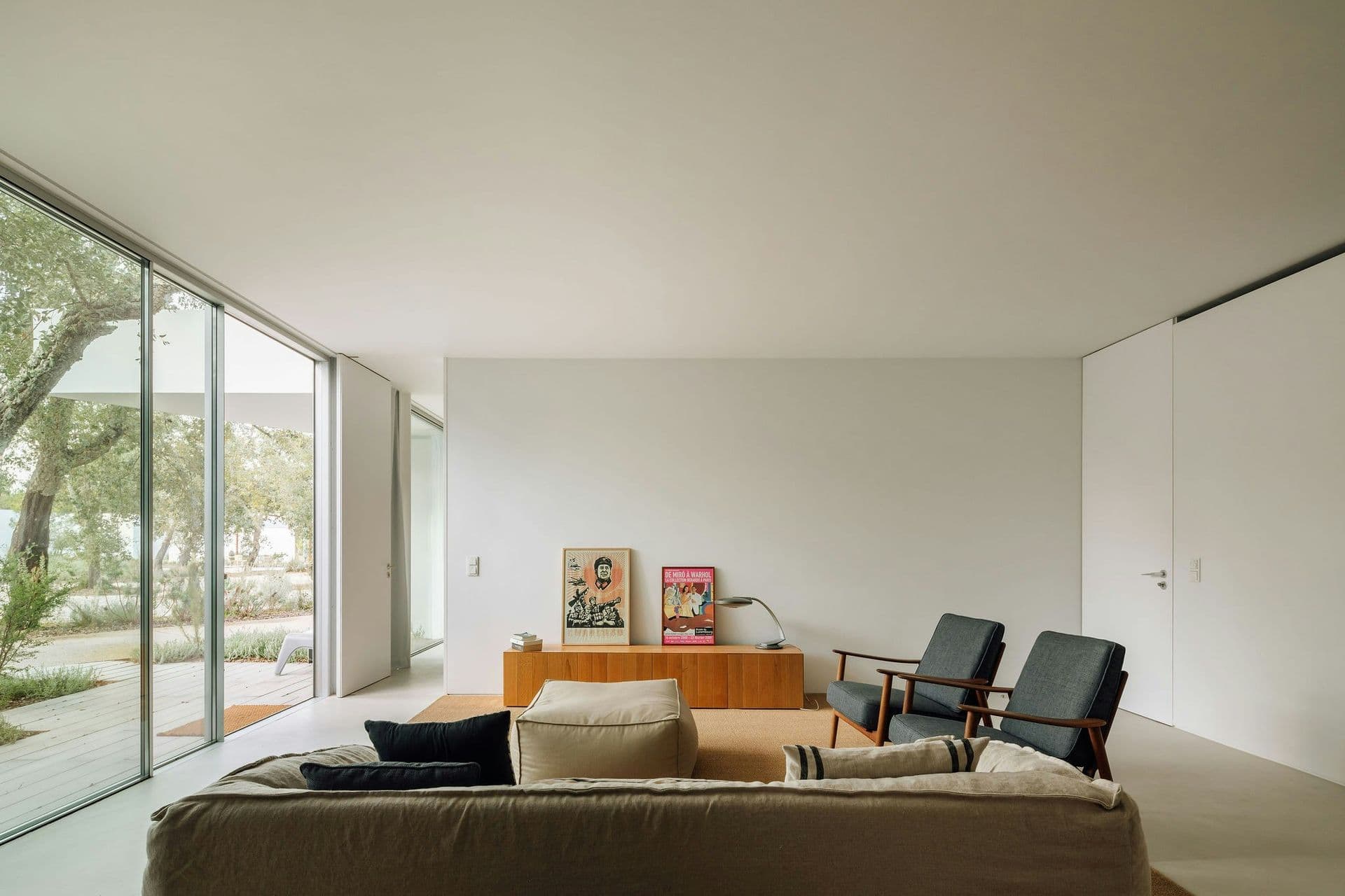 Sitting area with mid-century chairs and glass walls at The Spirit of Joy, Comporta
