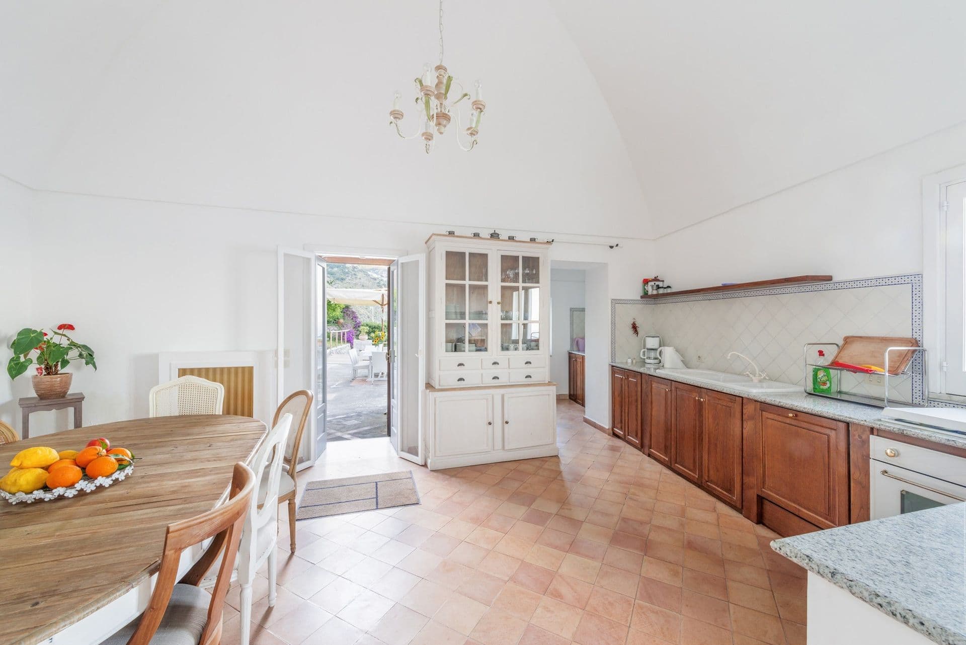 Vaulted kitchen with timber units and a dresser opening to the garden at Arch Above the Sea, Amalfi Coast