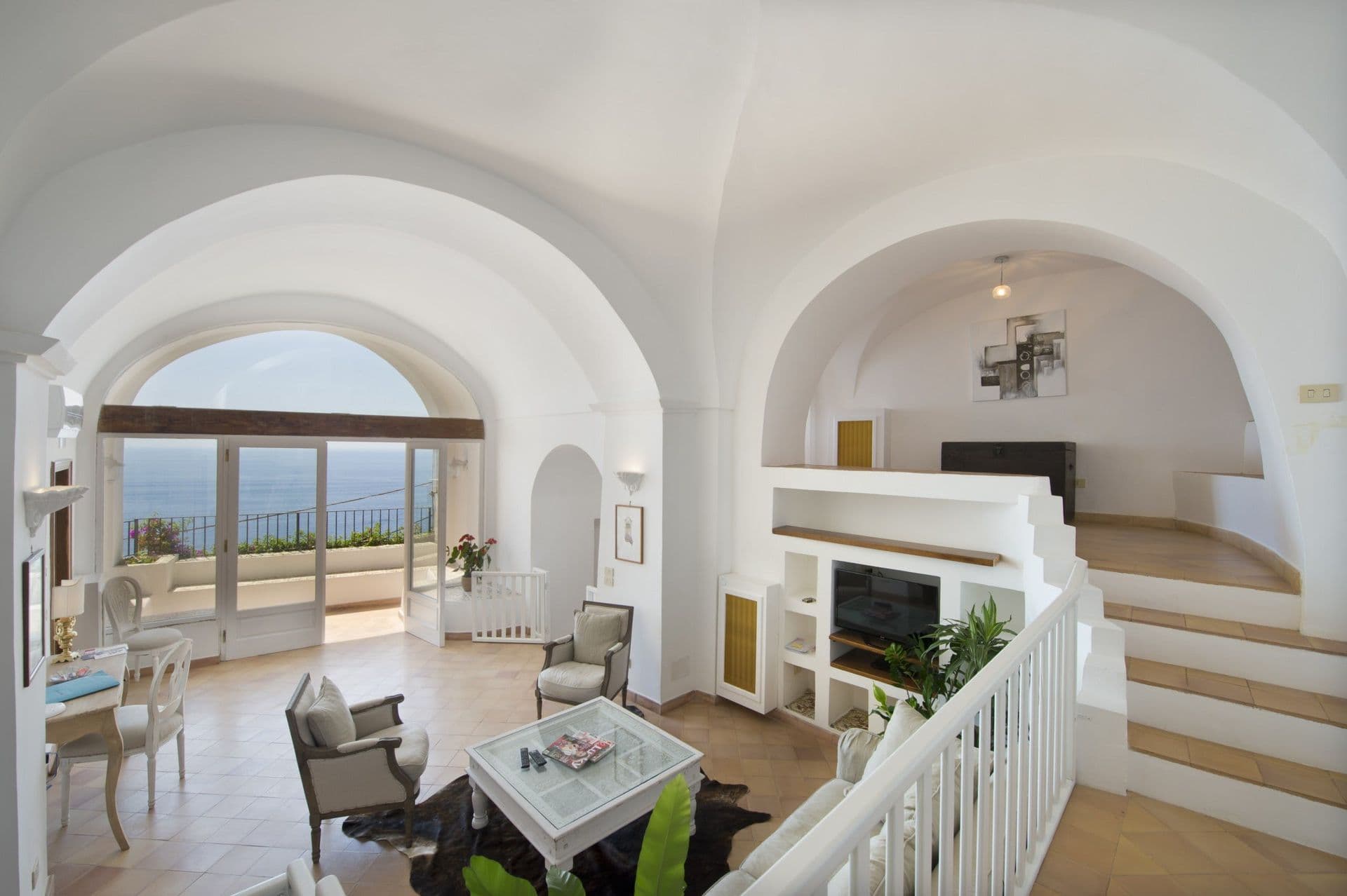 Vaulted living room with arched sea-view doors and a staircase at Arch Above the Sea, Amalfi Coast