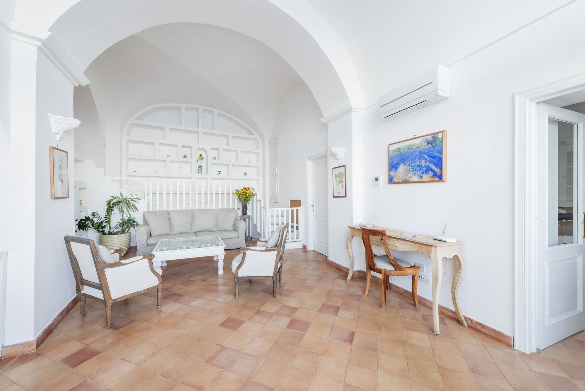 Vaulted reception room with sofas and a writing desk at Arch Above the Sea, Amalfi Coast