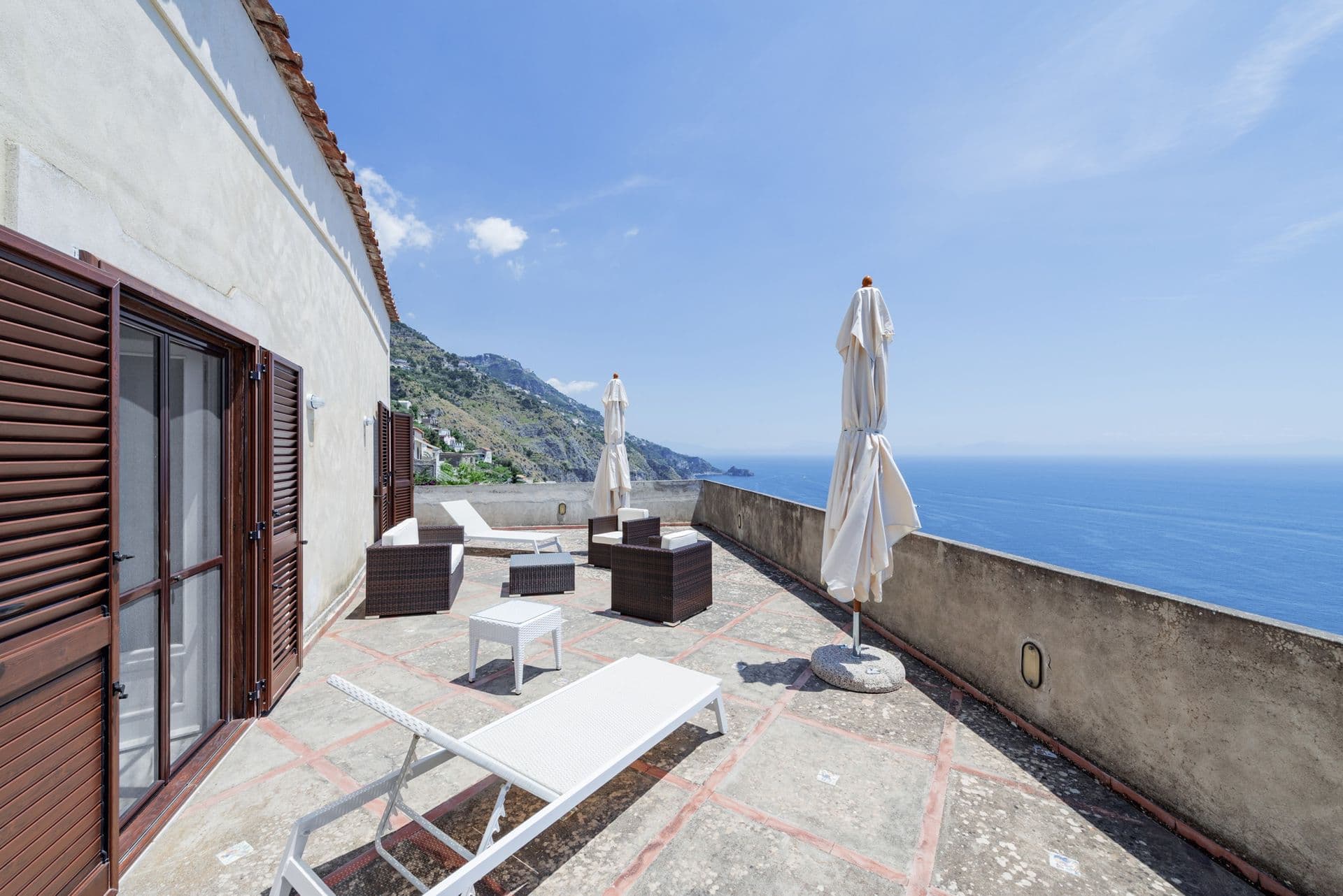 Rooftop terrace with sun loungers and parasols above the sea at Arch Above the Sea, Amalfi Coast
