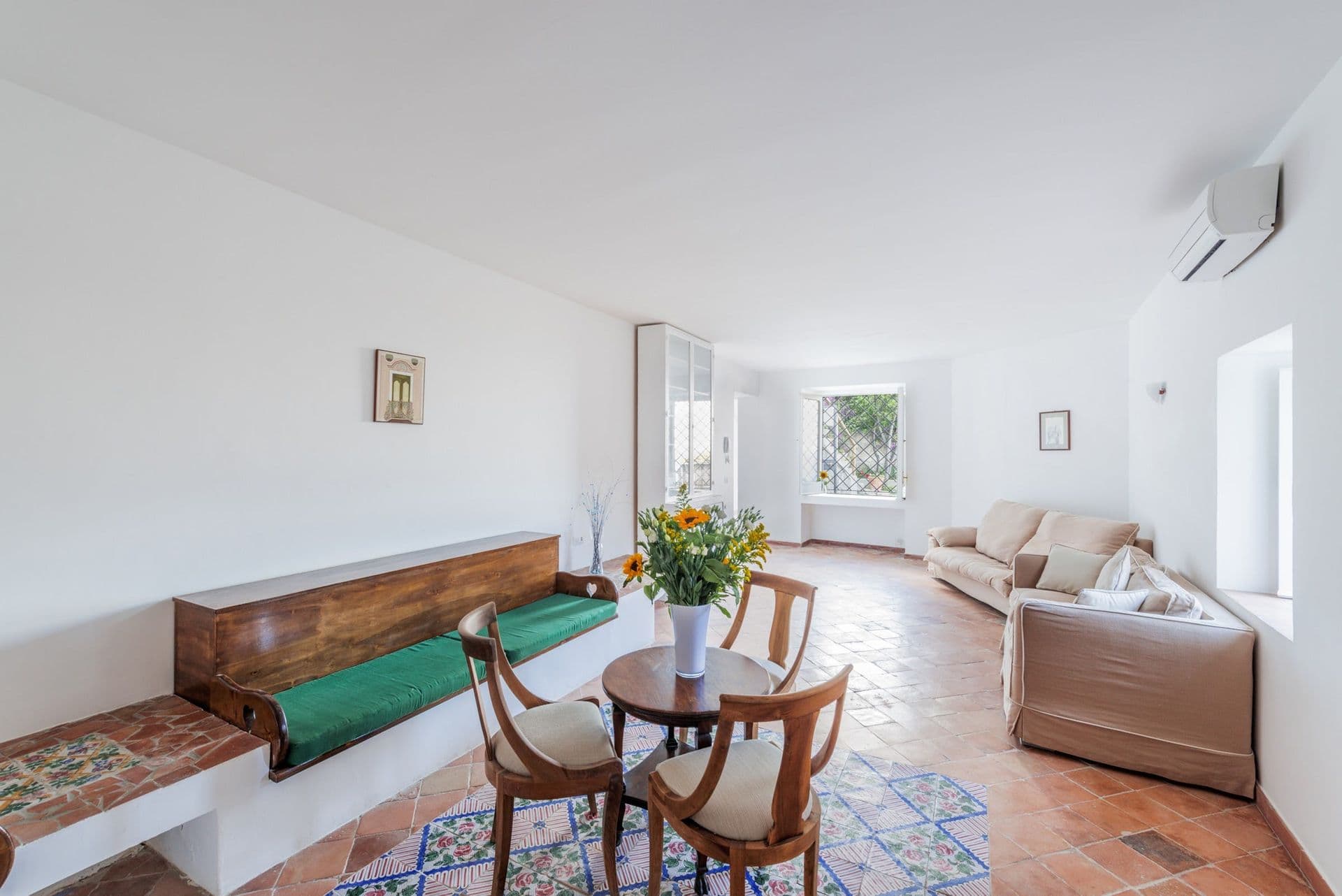 Bright vaulted sitting and dining area with a round table at Arch Above the Sea, Amalfi Coast