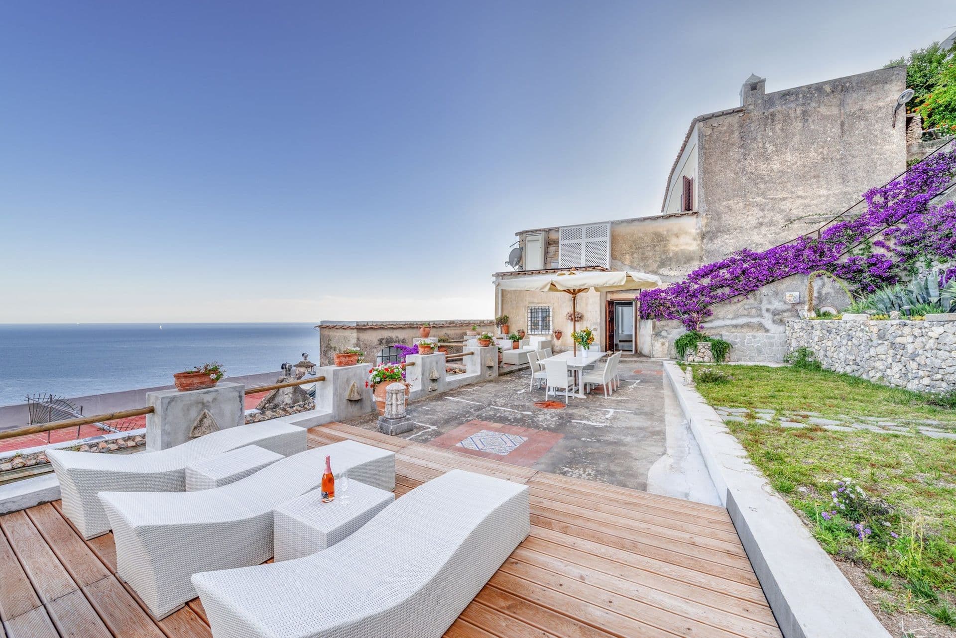 Sun terrace with sofas, bougainvillea and open sea views at Arch Above the Sea, Amalfi Coast