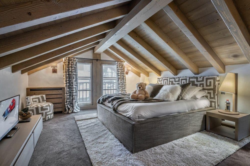 Double bedroom under a vaulted timber ceiling at Meribel 139