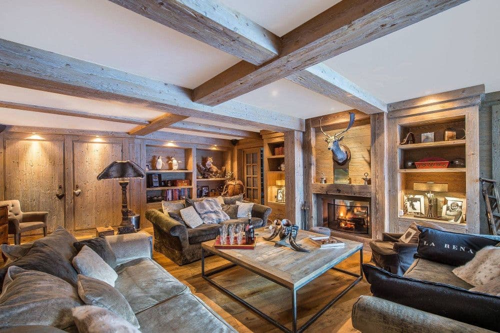 Fireside lounge with a lit fire and games table at Meribel 139