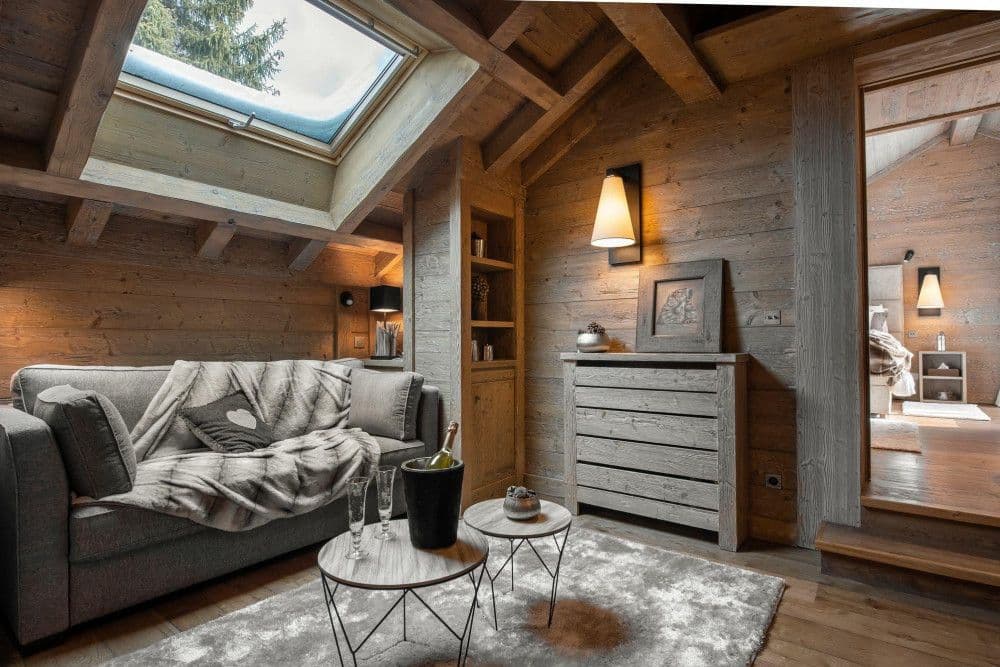 Sitting nook under a skylight with a sofa and champagne at Meribel 139