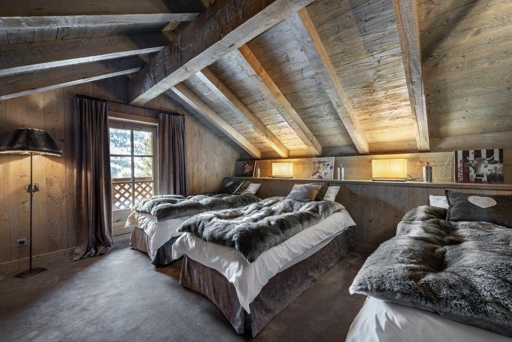 Twin bedroom under the eaves with fur throws at Meribel 139