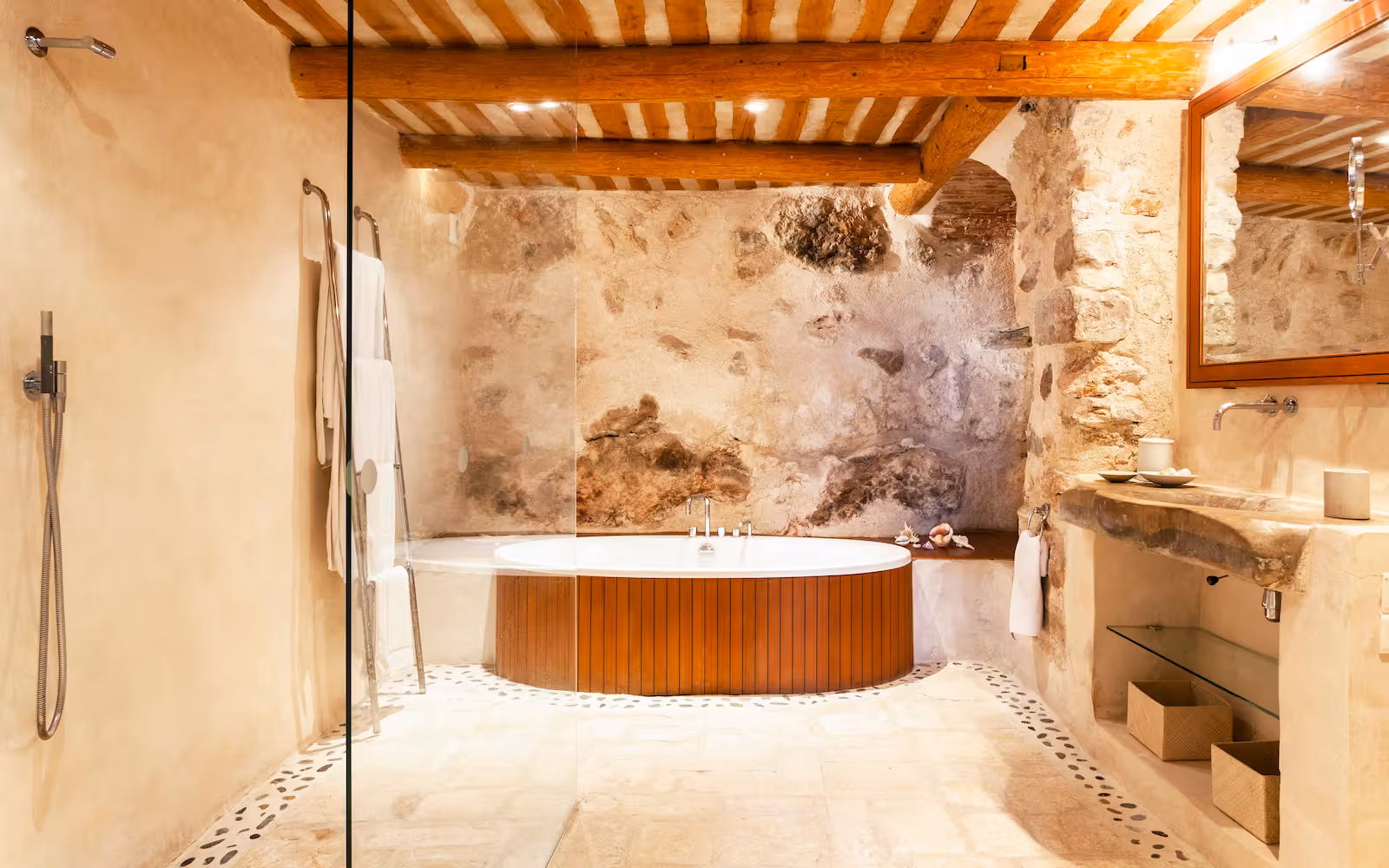 Rustic bathroom with an oval timber tub and walk-in shower in stone at Choral Words, Var, Provence