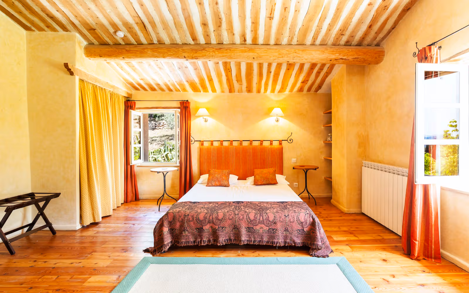 Bedroom with ochre walls, a terracotta headboard and a valley view at Choral Words, Var, Provence