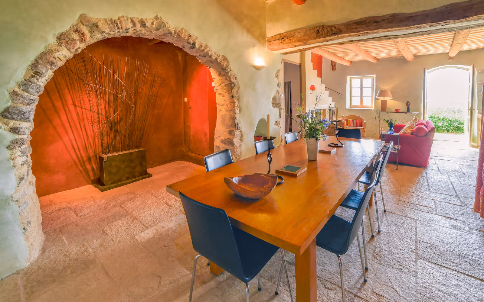 Dining room with a wood table set into a stone-arched niche at Choral Words, Var, Provence