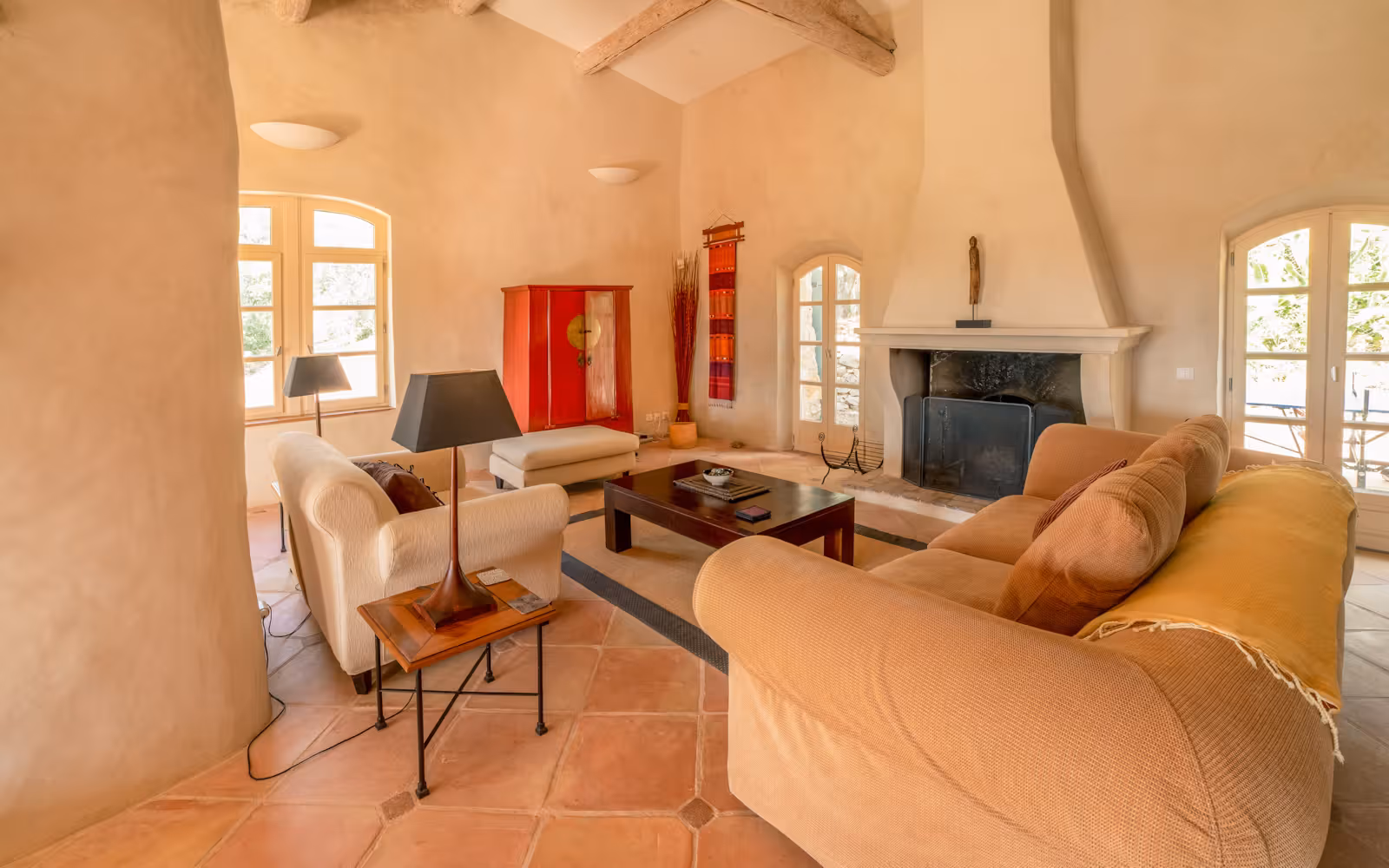 Sitting room with beige sofas, a stone fireplace and arched windows at Choral Words, Var, Provence