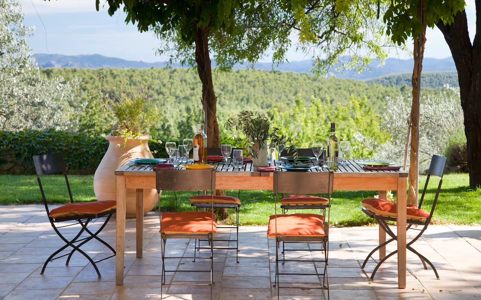 Outdoor dining table under a wisteria pergola with hill views at Choral Words, Var, Provence