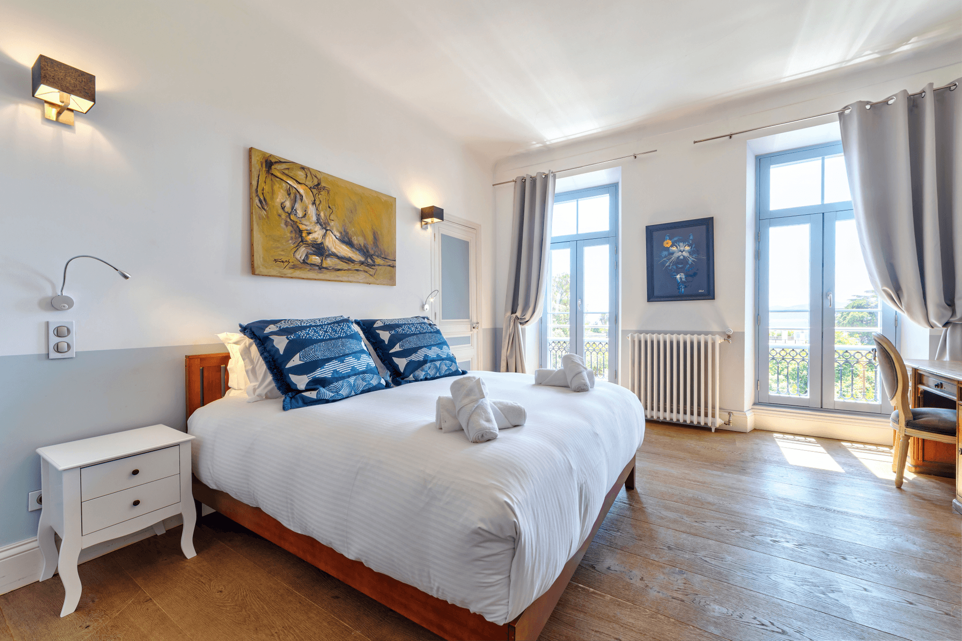 A guest bedroom with navy accent cushions and French doors onto a balcony