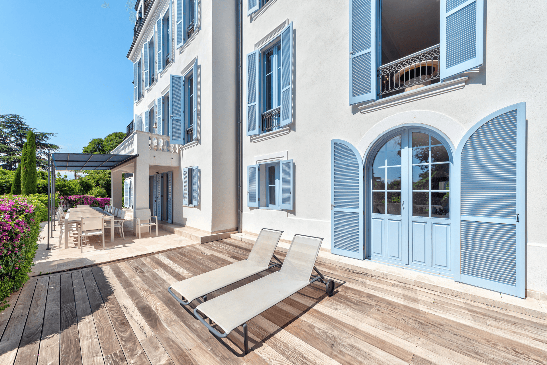 The pale blue shuttered facade of The Lark's Song villa with a wooden sun deck