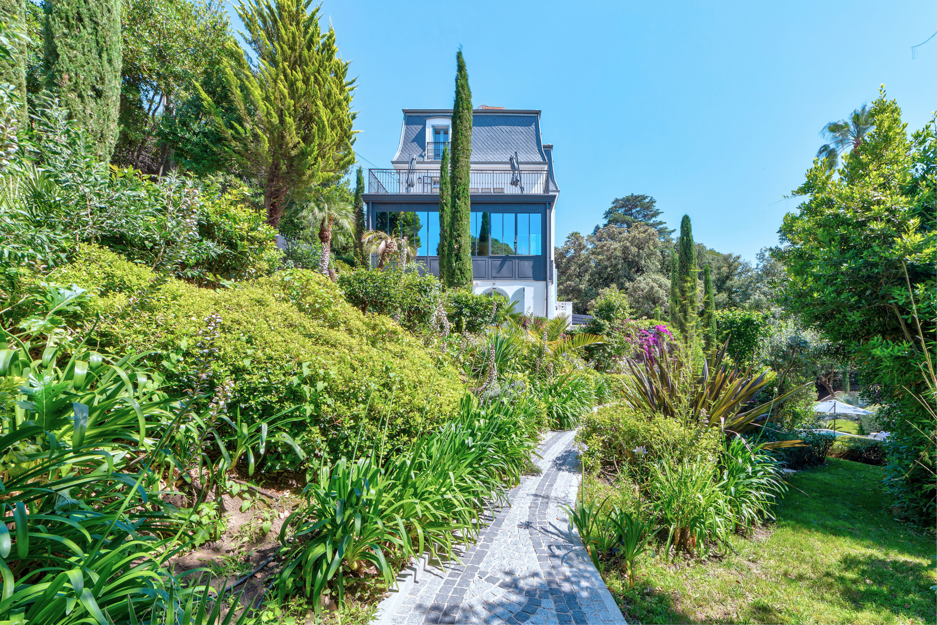 A stone path winding through the lush subtropical gardens of The Lark's Song