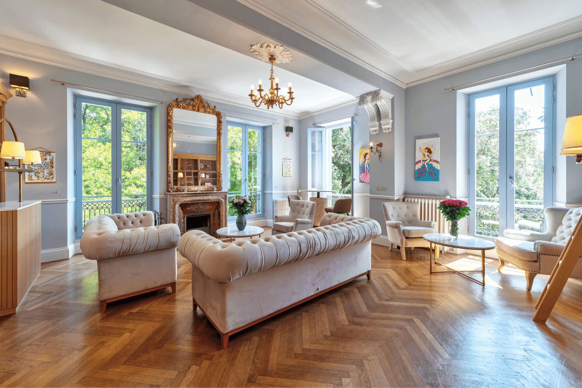 A second sitting room with chesterfield sofas, chandelier and garden views