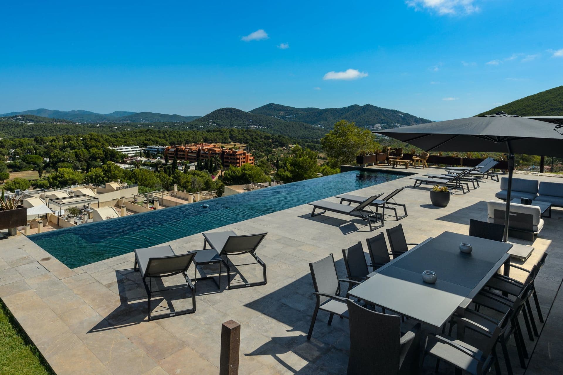Pool terrace with sun loungers and a games area in the background