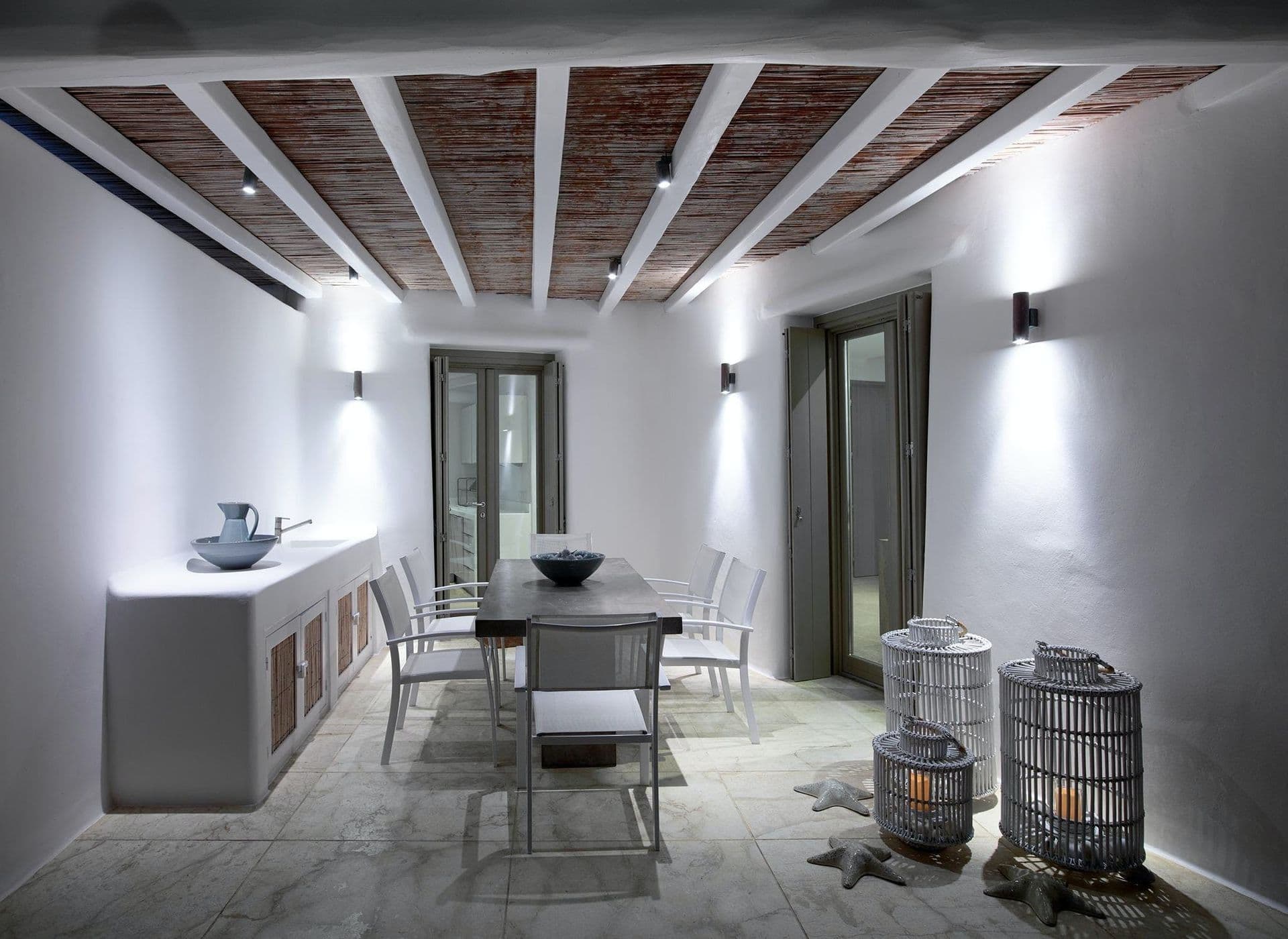 Indoor dining area with a beamed ceiling and a sideboard laid with crockery.