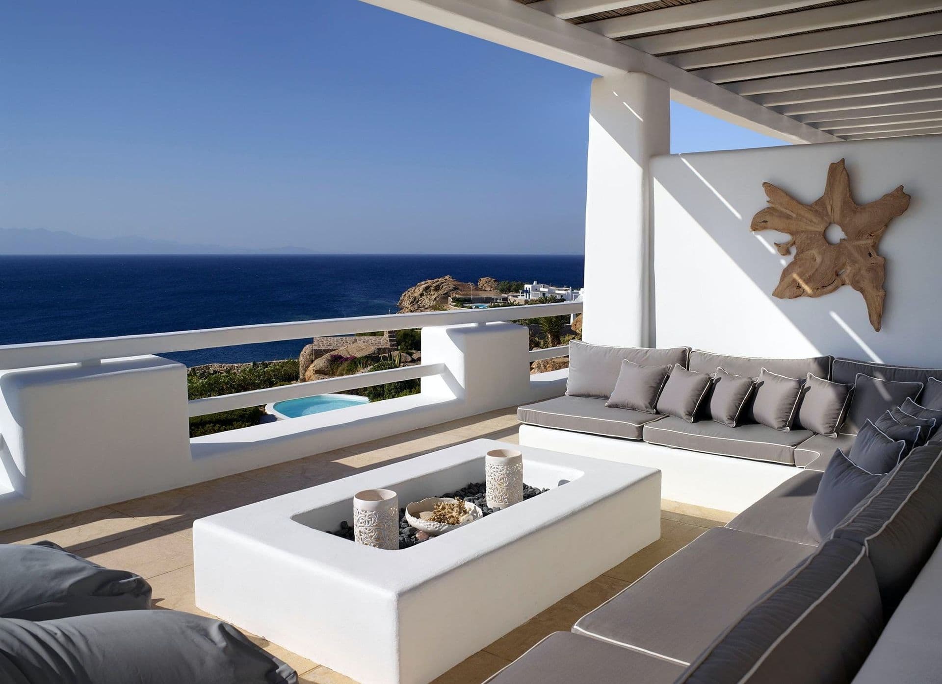 Firepit lounge area with built in seating overlooking the coastline.
