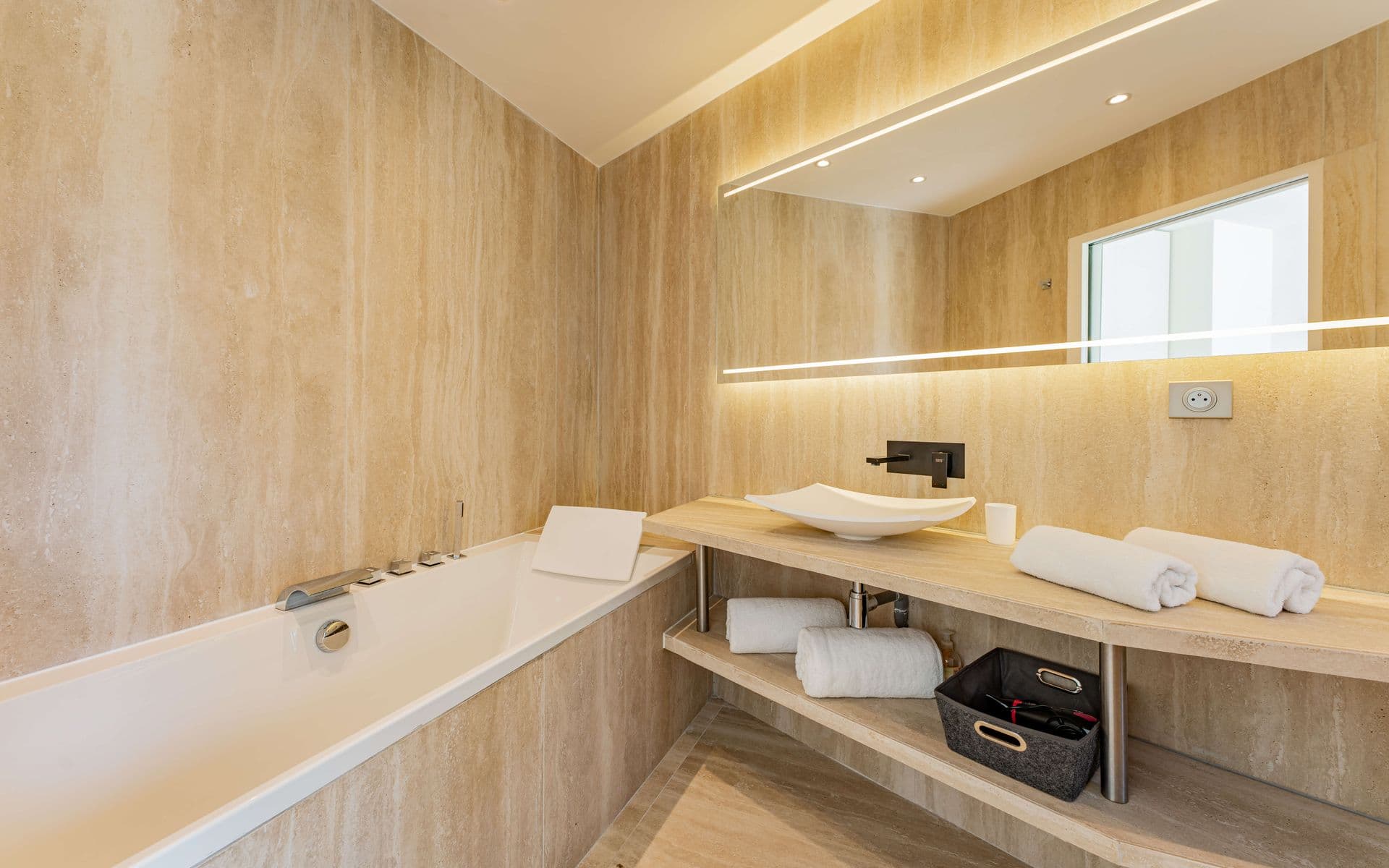 Wood-clad en-suite bathroom with a double vanity and built-in bathtub.