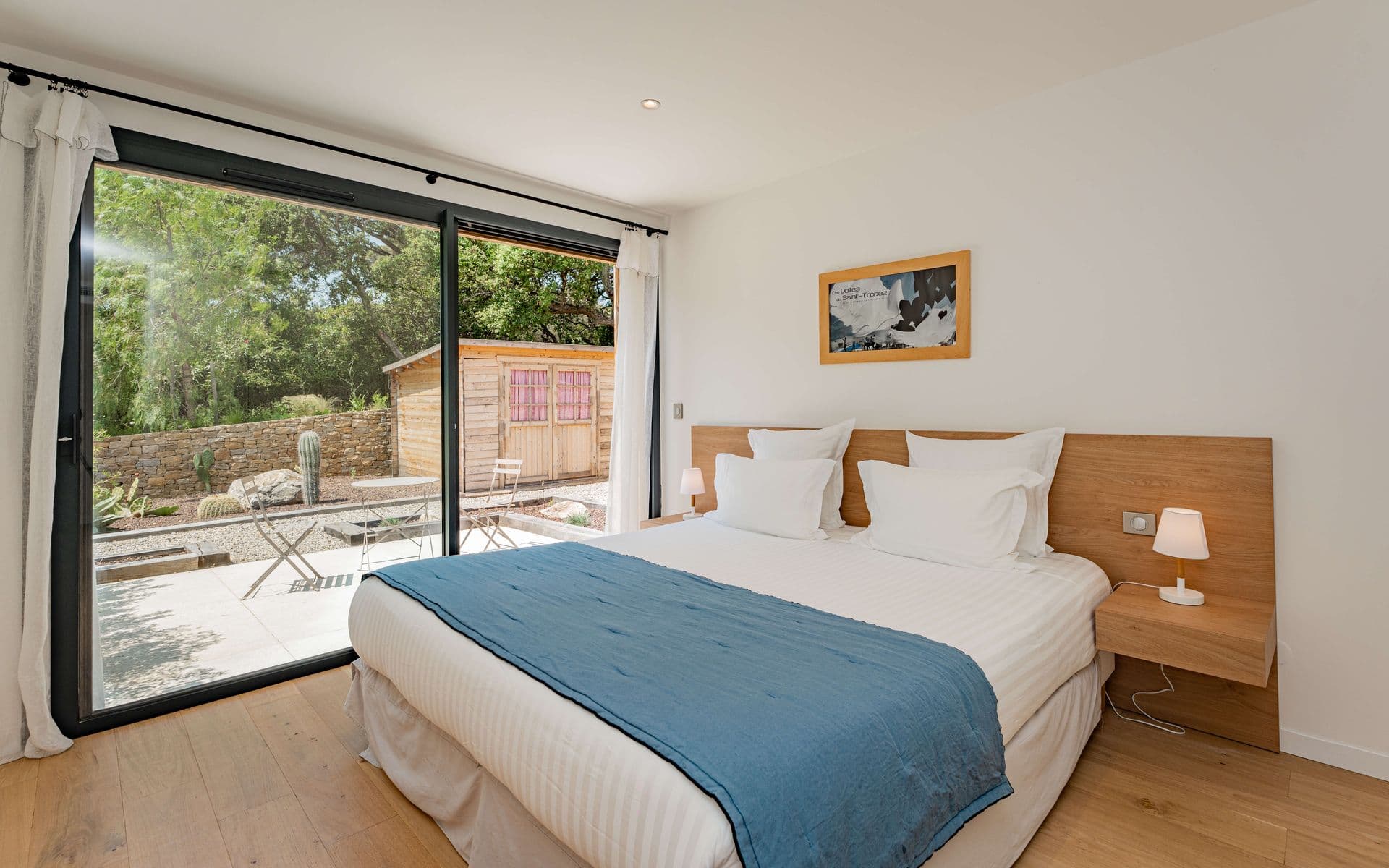 Bedroom with a denim-blue throw and wall-mounted television.