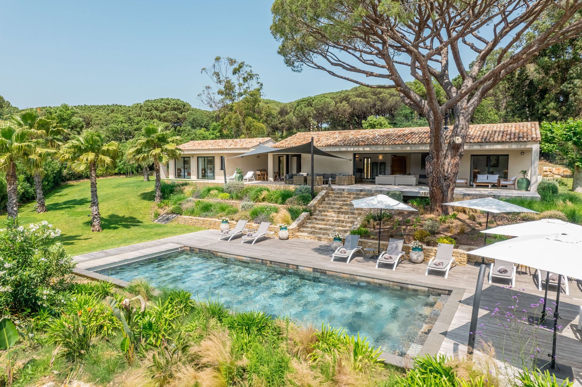Single-storey villa and pool viewed across the landscaped garden.