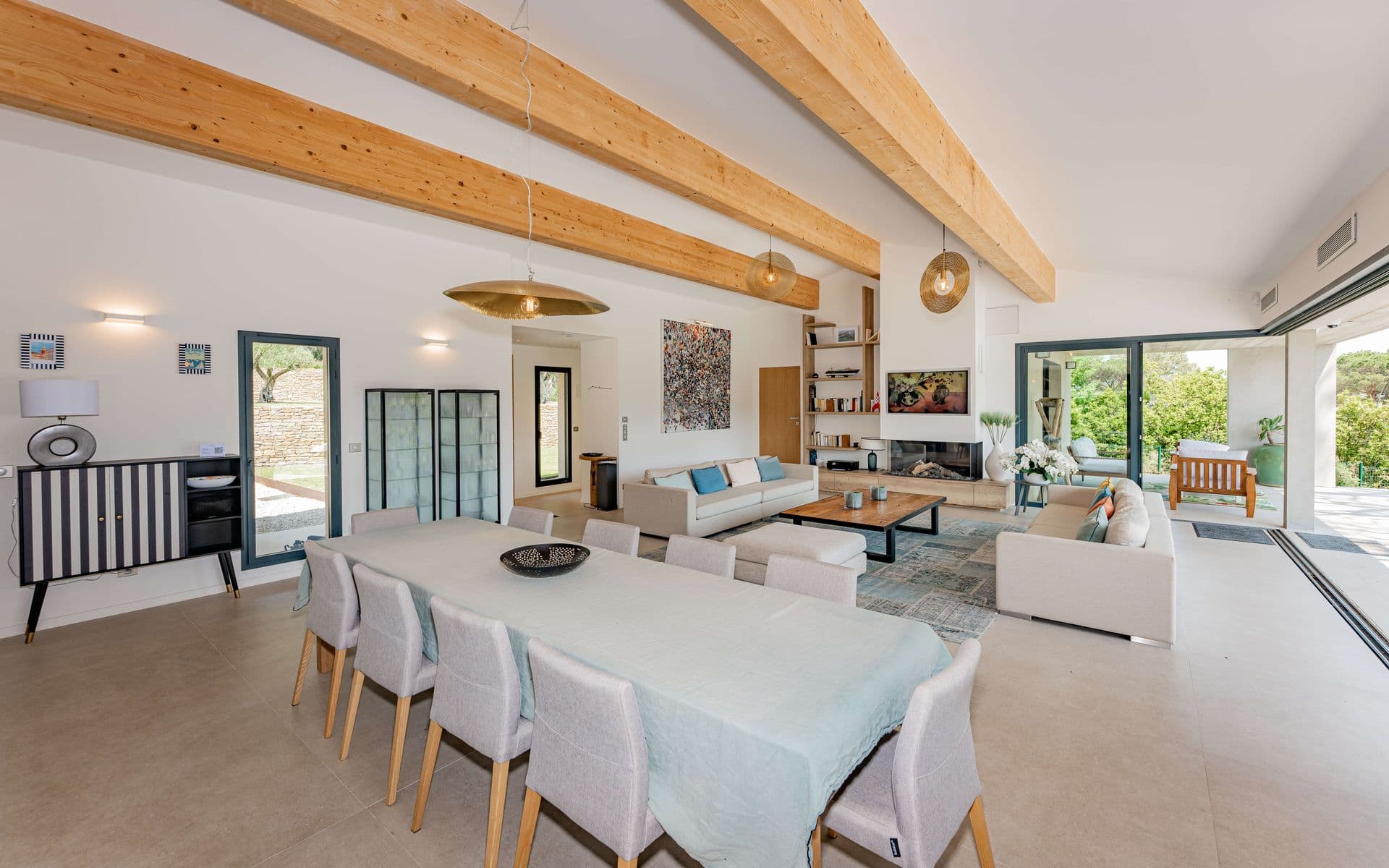 Open-plan living and dining room with exposed timber beams.
