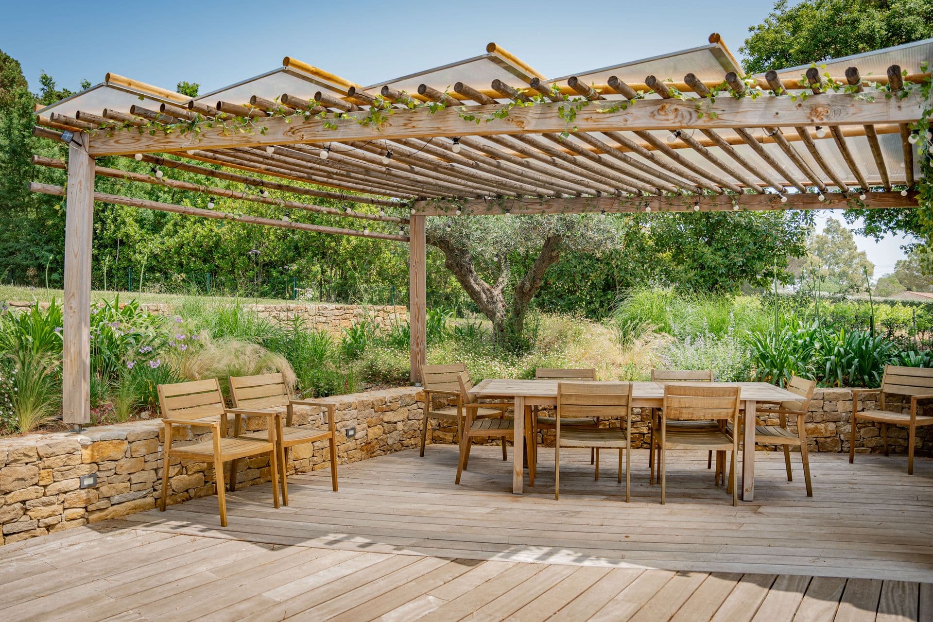 Outdoor dining table for ten under a timber pergola.