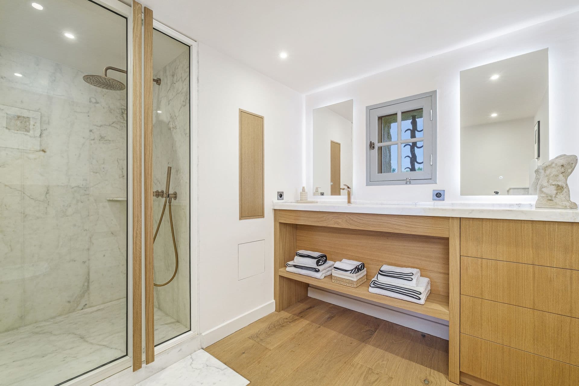 Ensuite bathroom with a marble walk-in shower and wood vanity