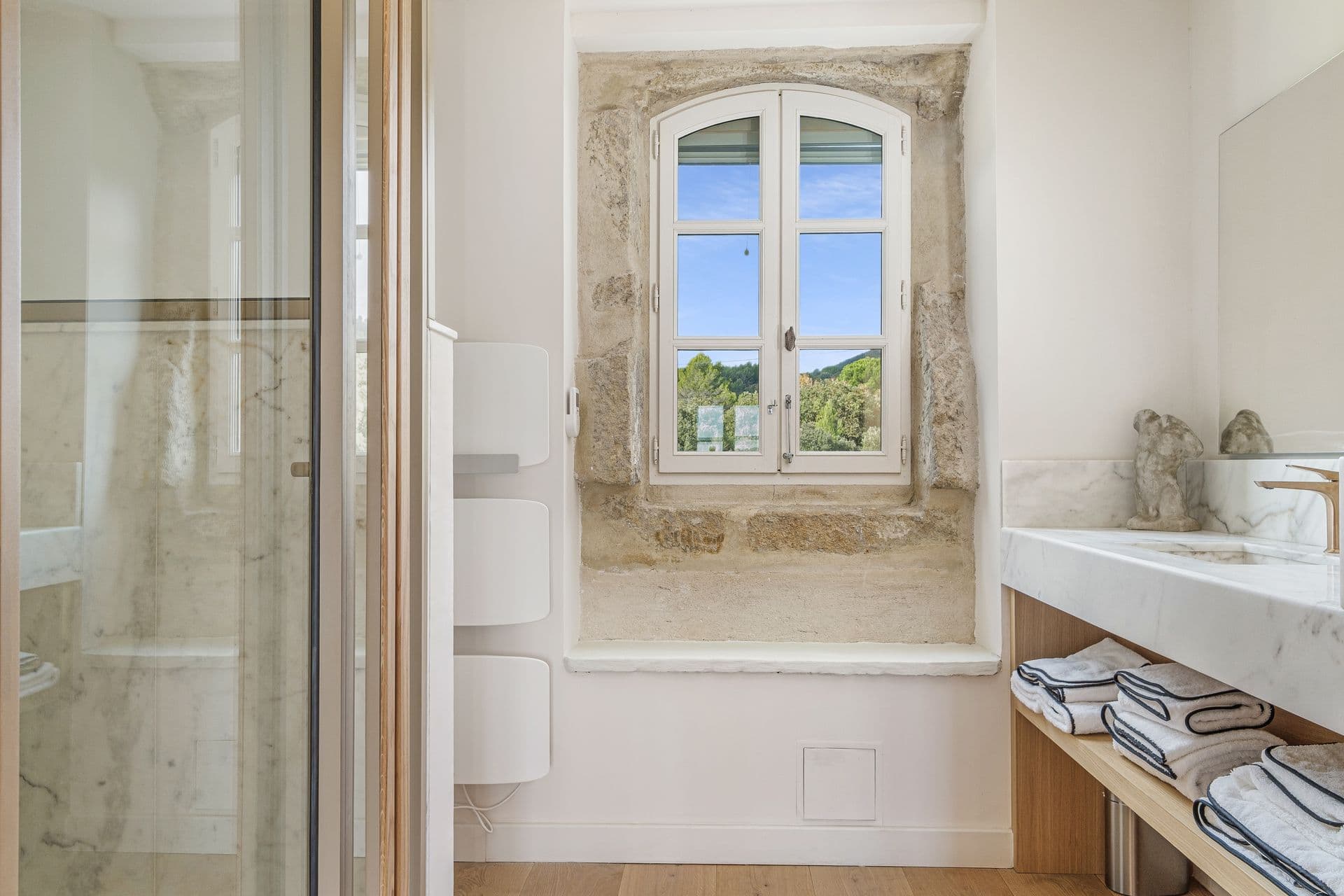 Bathroom with an original stone-arched window nook and marble counter