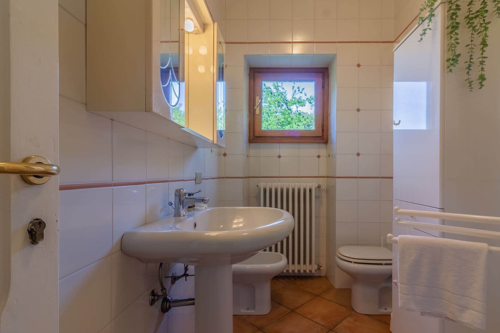Bathroom with pedestal sink and window at So Bellagio villa