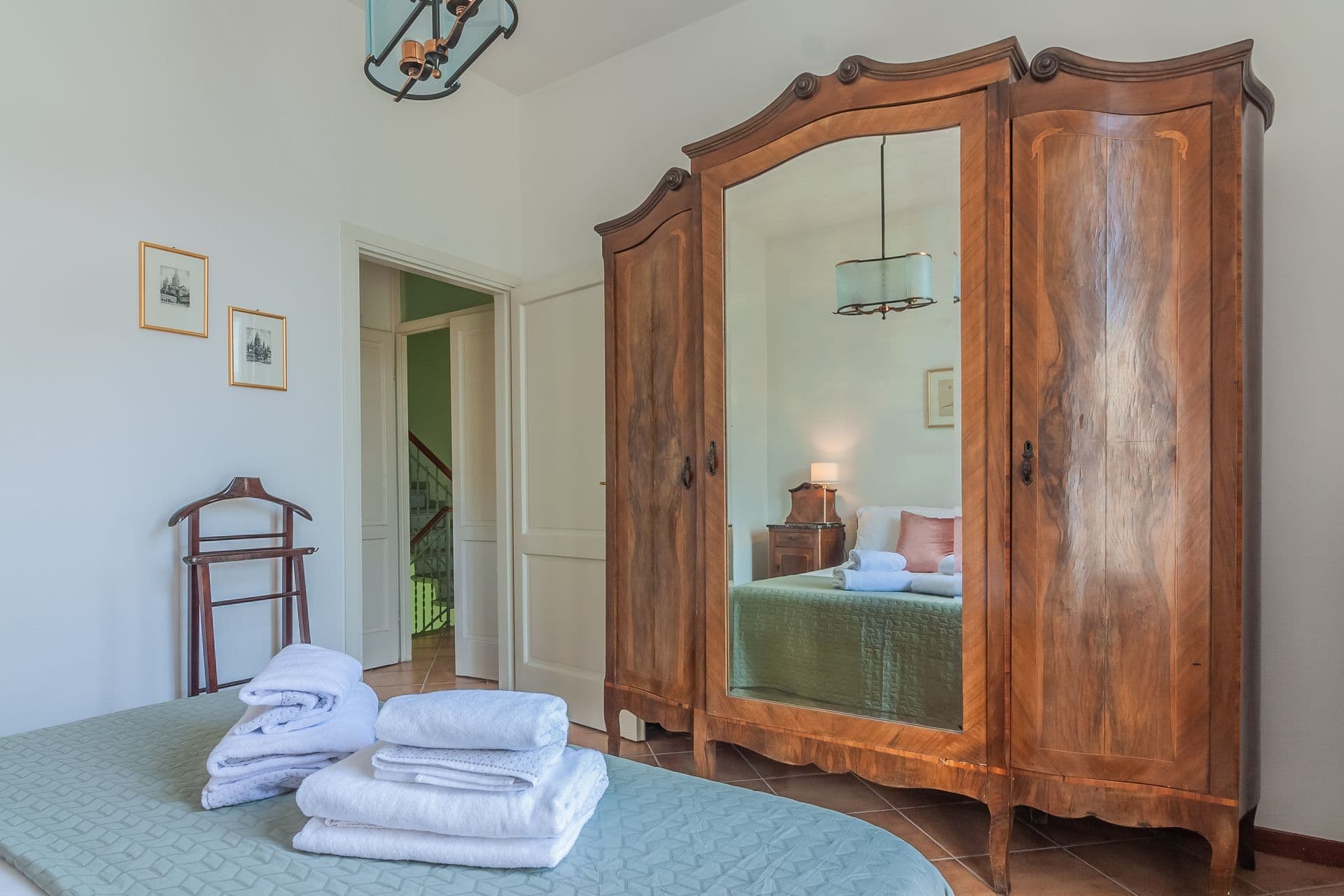 Bedroom with an antique mirrored wardrobe at So Bellagio