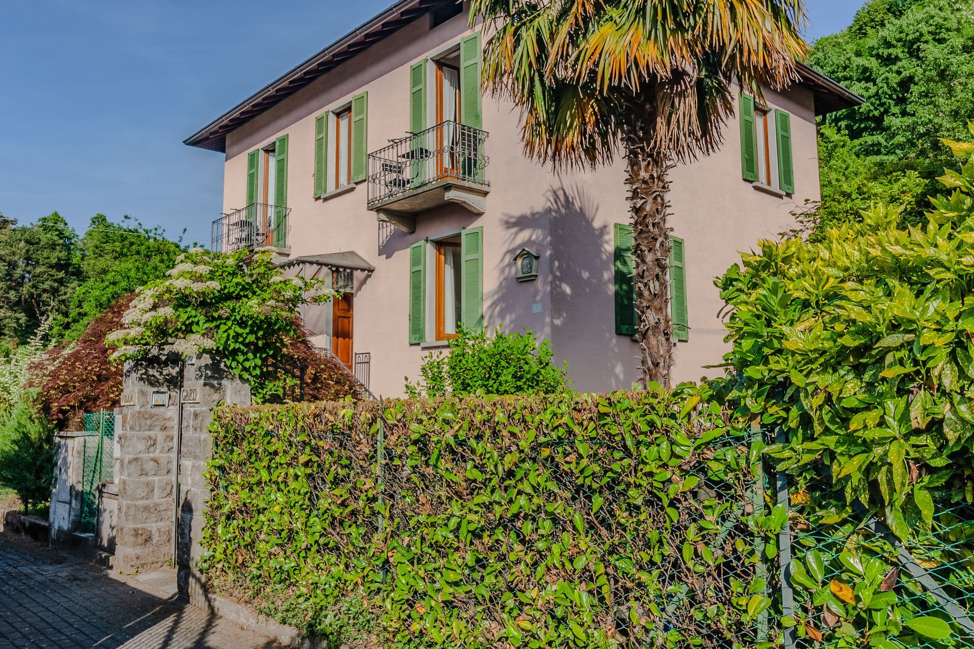 So Bellagio, a pink Italian villa with green shutters and a garden on Lake Como