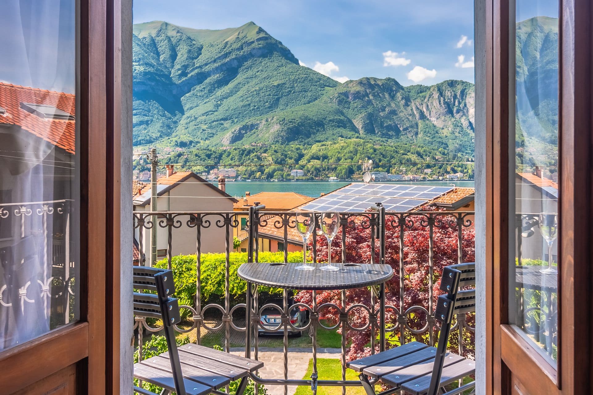 View of Lake Como and the surrounding mountains from a balcony window at So Bellagio