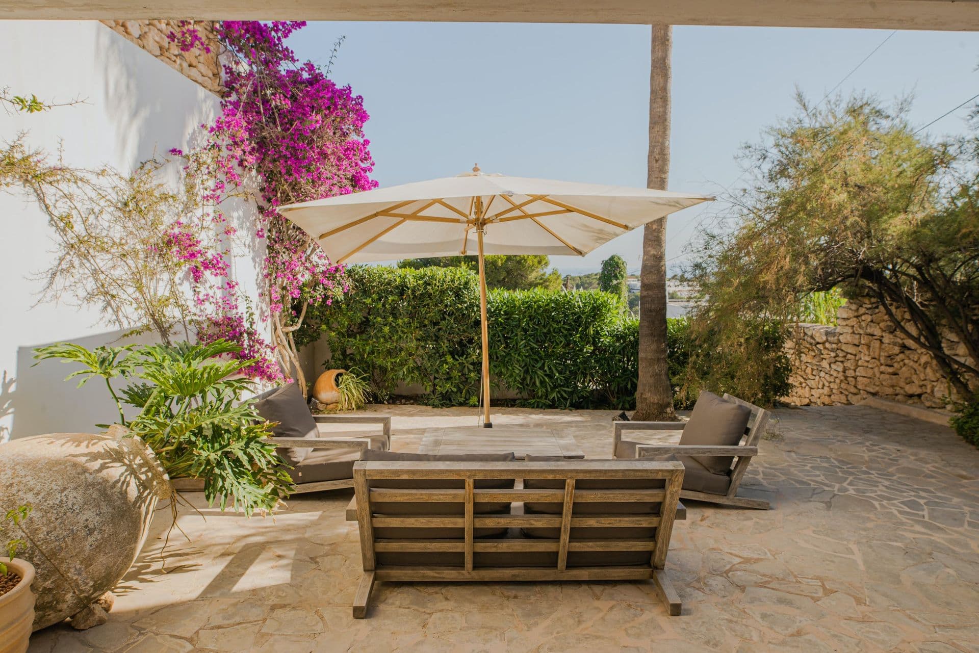Sheltered courtyard lounge area framed by bright pink bougainvillea at New Beat